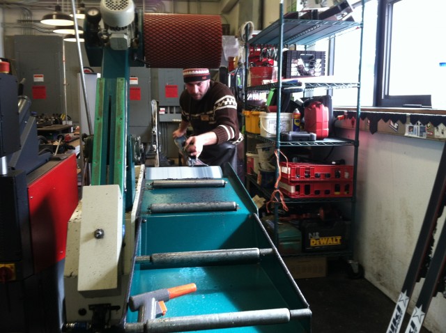 One of Whiteface Mountain's expert Ski Tuners uses a machine to flatten the ski before edging