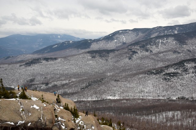 Hikers dressed in down jackets and snow pants enjoy one of the many open knobs on Mount Pitchoff.