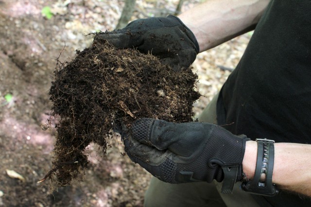 The top layer of forest floor, called duff, is removed to make a new trail.