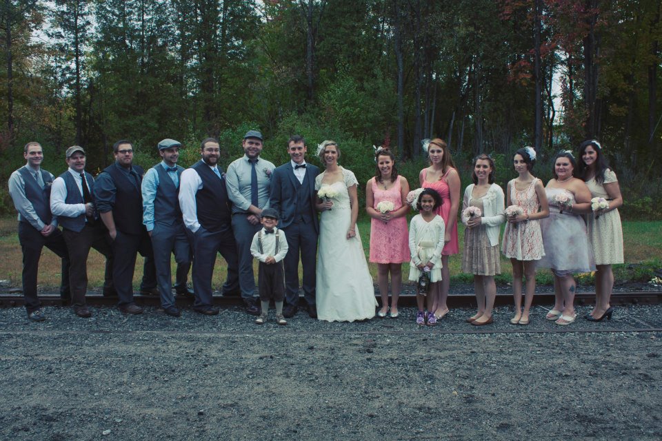 Faith & Andrew share a moment with their wedding party outside of the Tupper Lake Train Depot (Emily Lauren Photography)