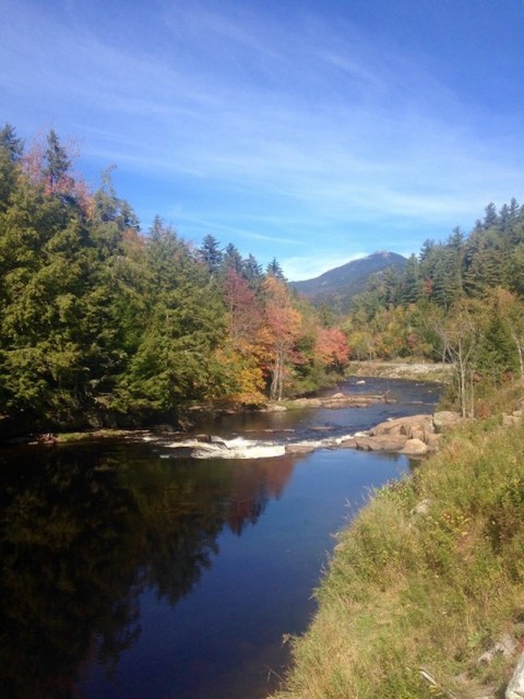Hot fall color begins between the cool blues of sky and river.