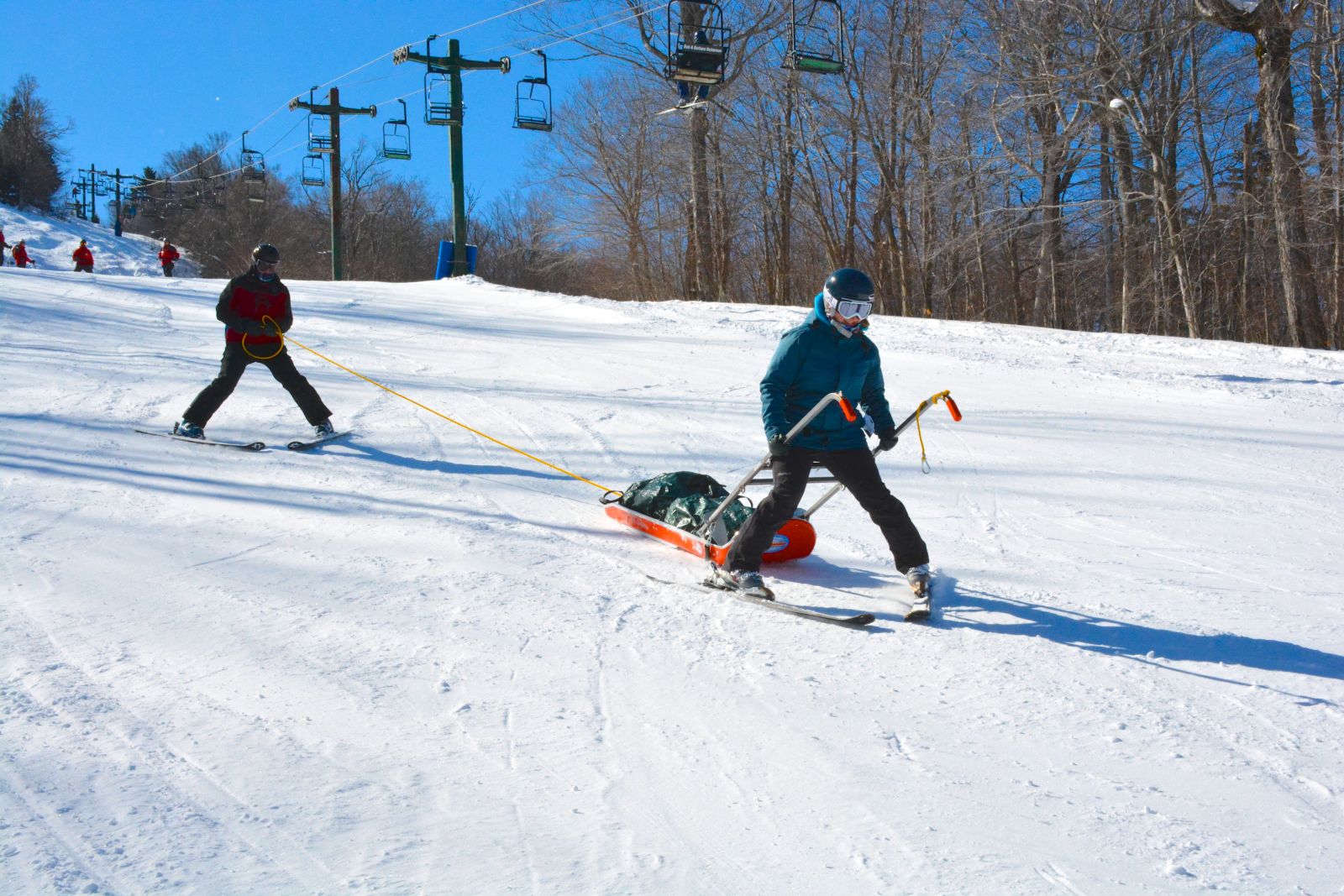 I learned how to drive the sled down Lift Line. Anne Maltais, a Big Tupper patroller, is seen handling the tail rope at the rear of the sled.