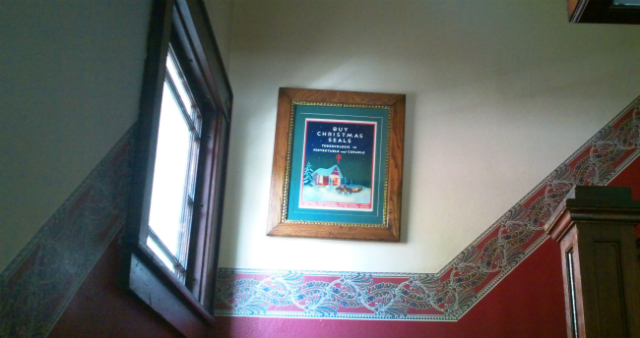 Christmas seals began in Denmark, as a way of raising funds for children with tuberculosis A Christmas seal hangs on the wall on a landing up the stairs of a cure cabin in Saranac Lake.