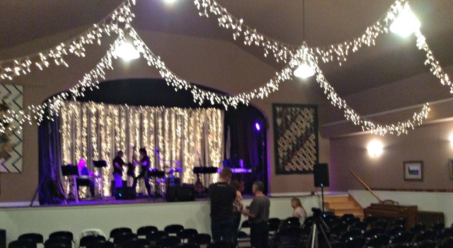 Tally and her band sets up on stage while concert goers mingle in the lobby.