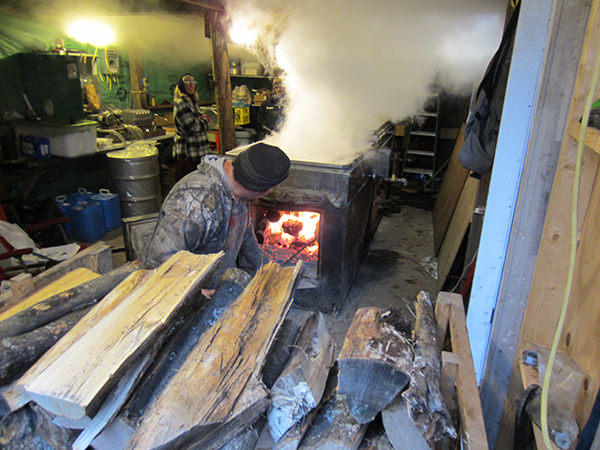 Owner Kevin Sayre stokes the fire as sap boils.