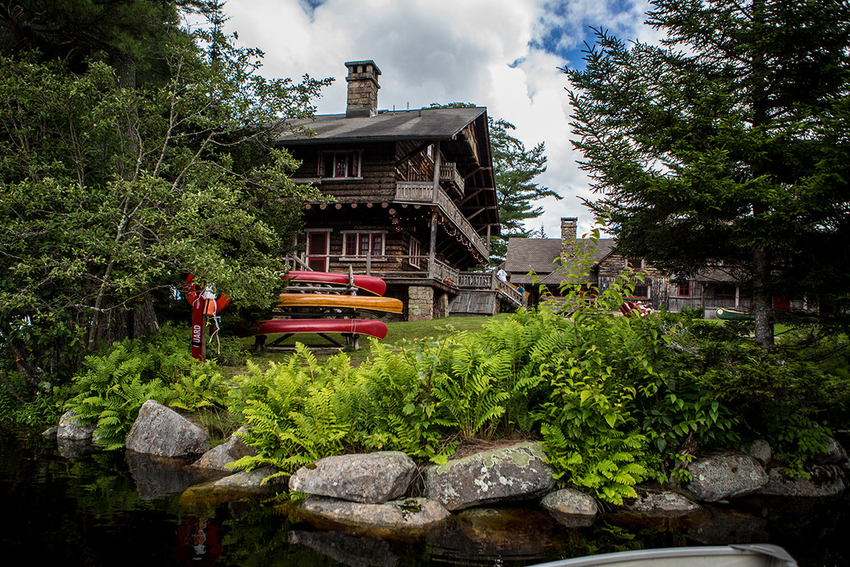 Brightly-colored kayaks next to the Main Lodge at historic Great Camp Sagamore.