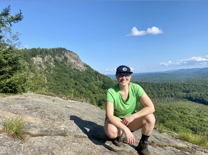 woman posing in front of rocky summit in the background