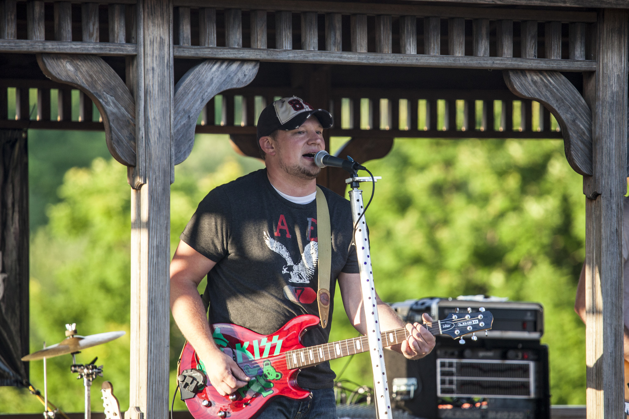 A man plays the guitar as he sings during a live performance.