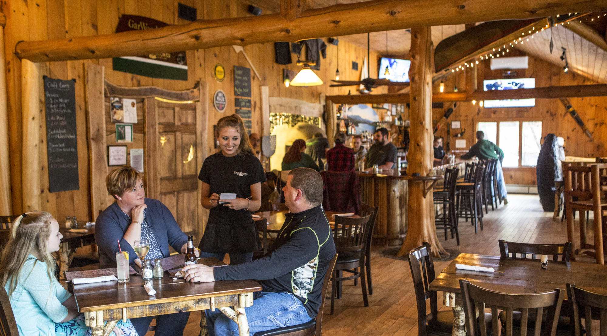 Waitress takes family's order in rustic restaurant 