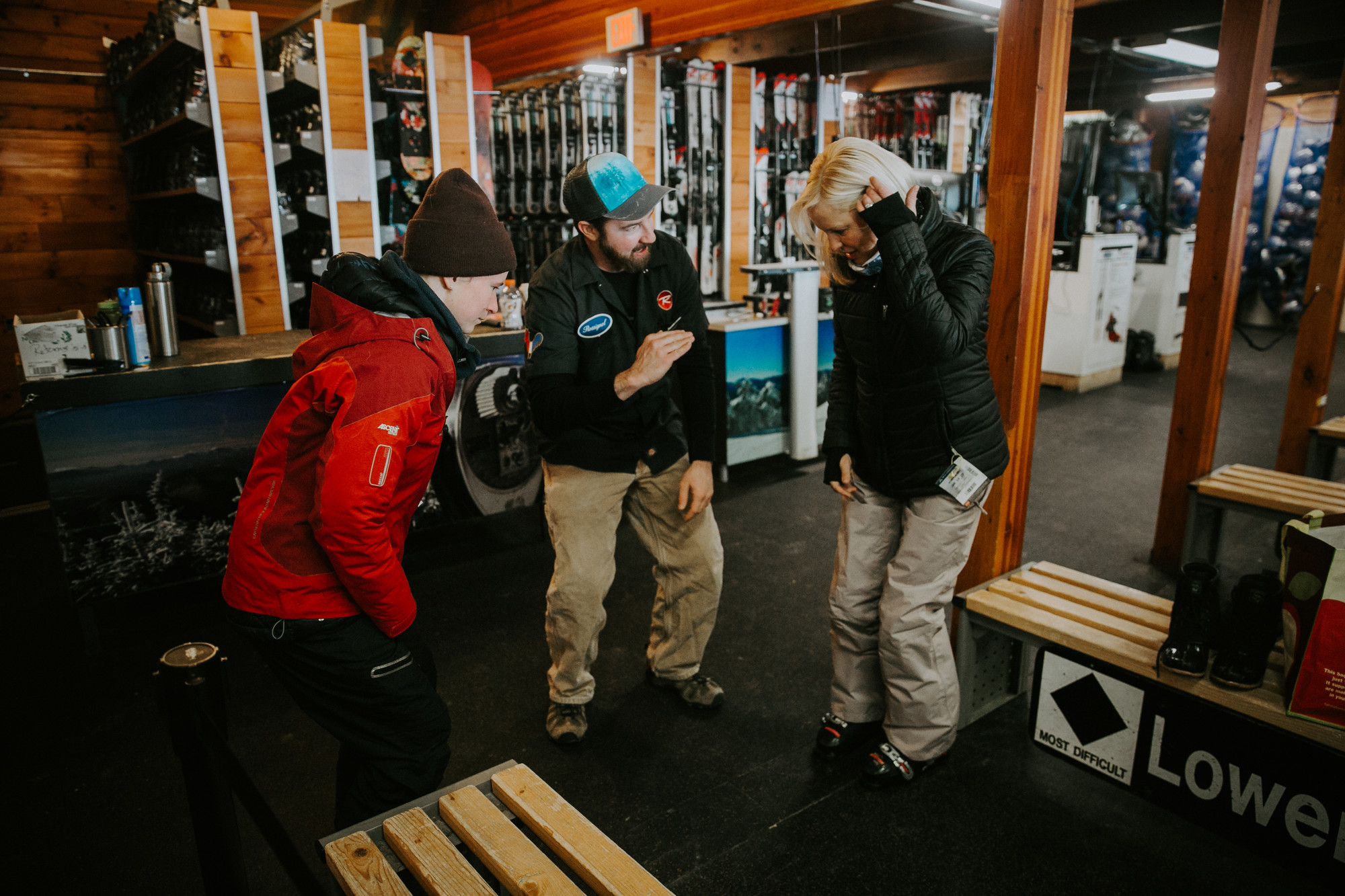 Two skiers getting outfitted with rental equipment. 
