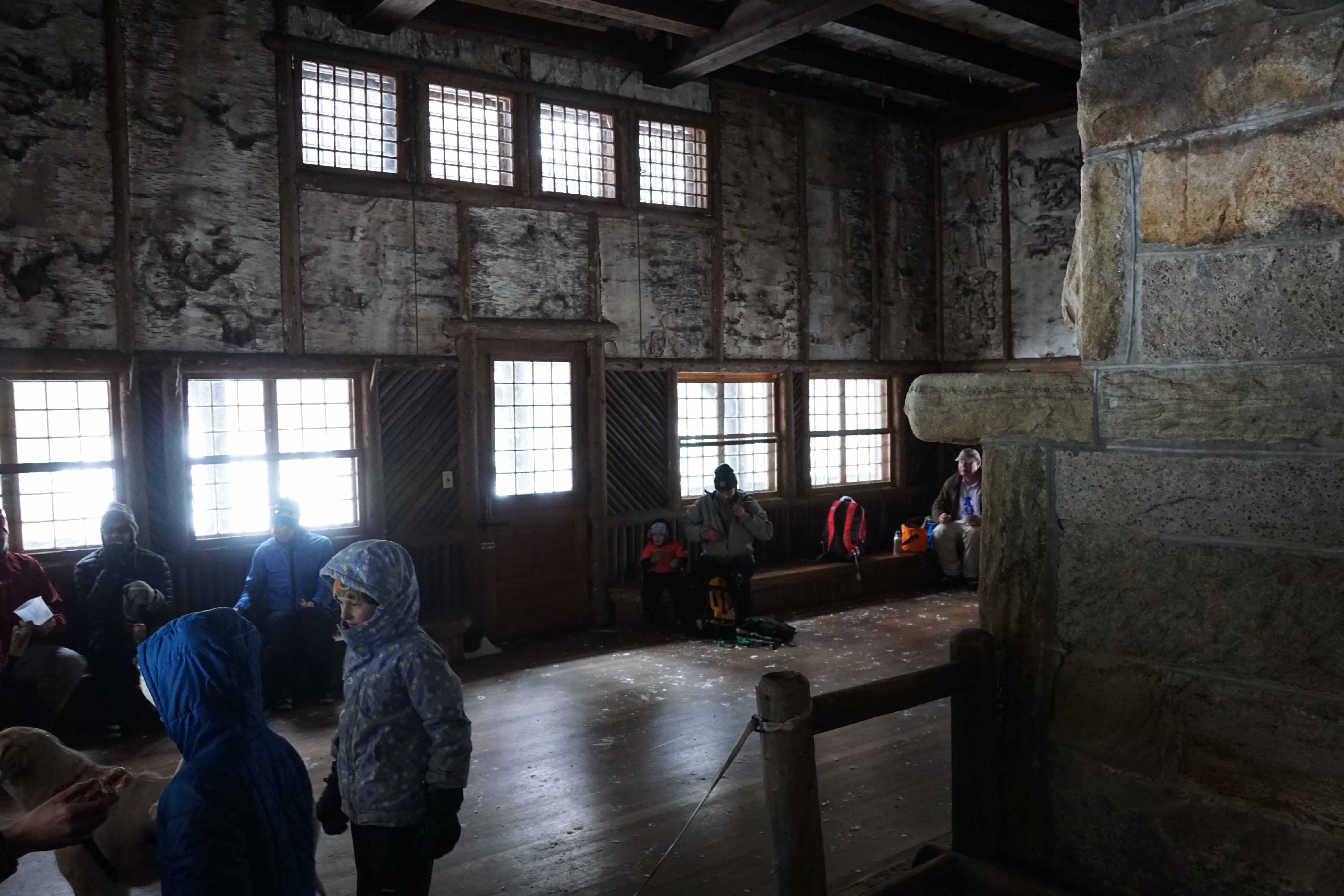 A group of people picnicked in the main room of the lodge.
