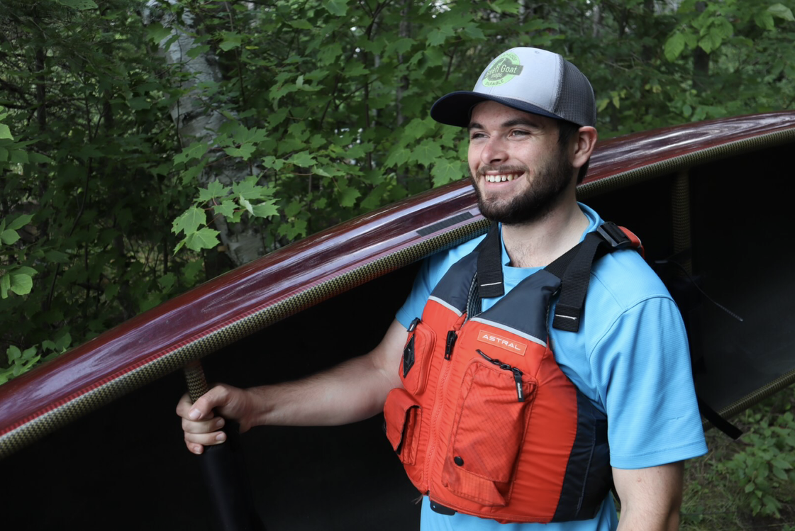 A man holds up a canoe.