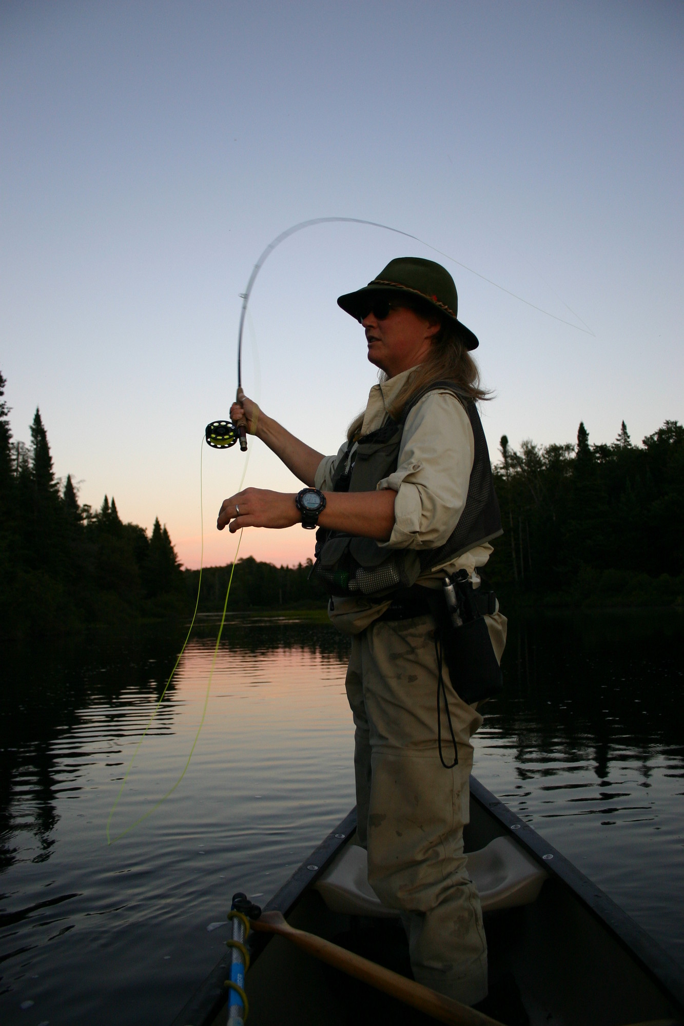 woman fishing in the early morning from her boat