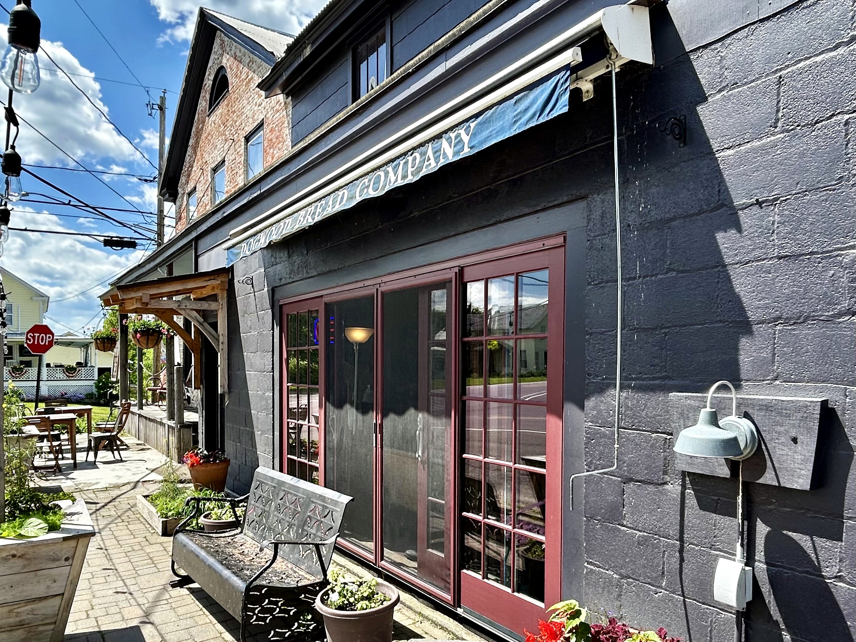 The exterior of a bakery in a tidy, old fashioned farmhouse.