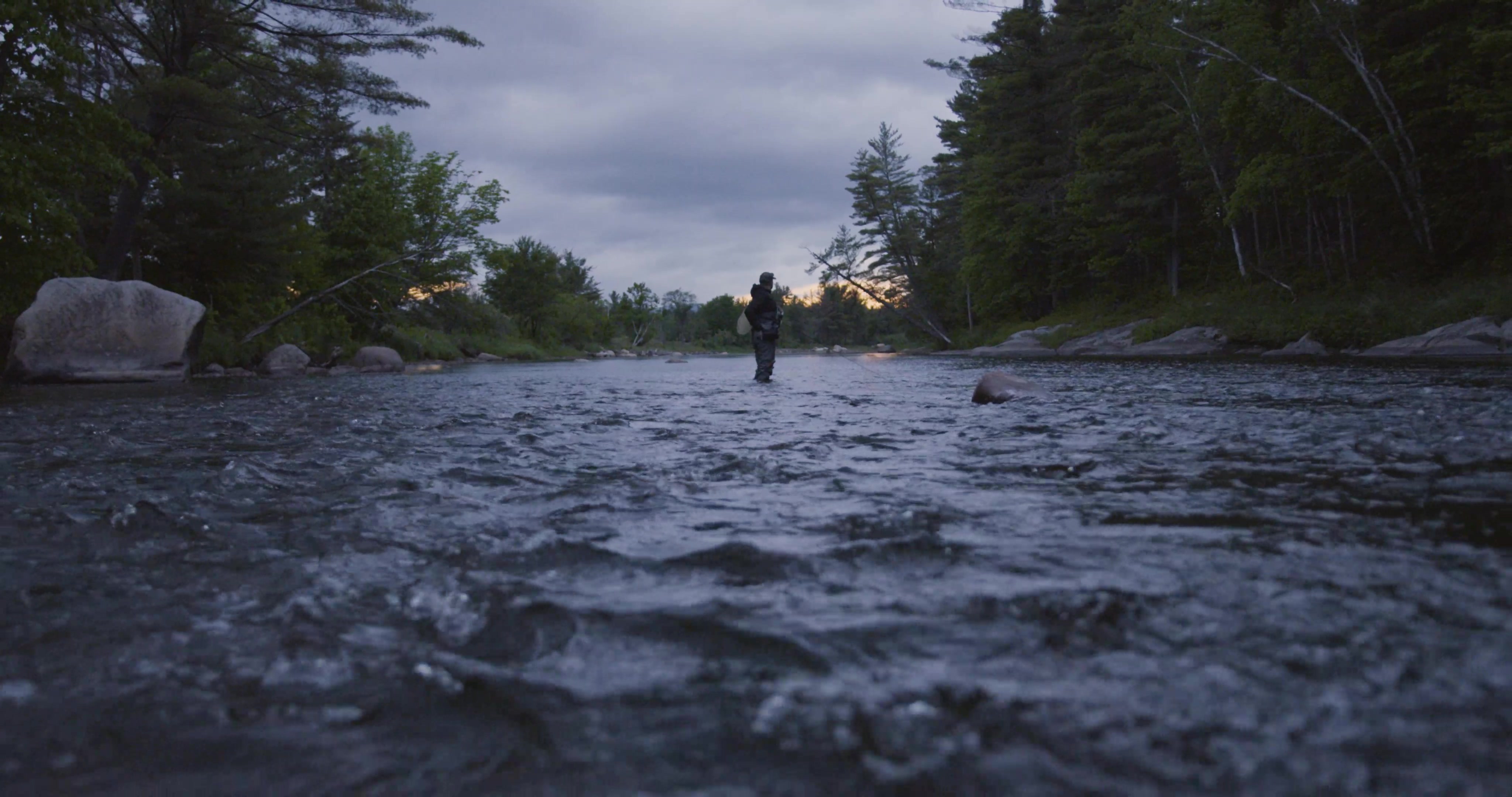 From close to the water, we see Bottcher standing in the river preparing to cast in the early morning light