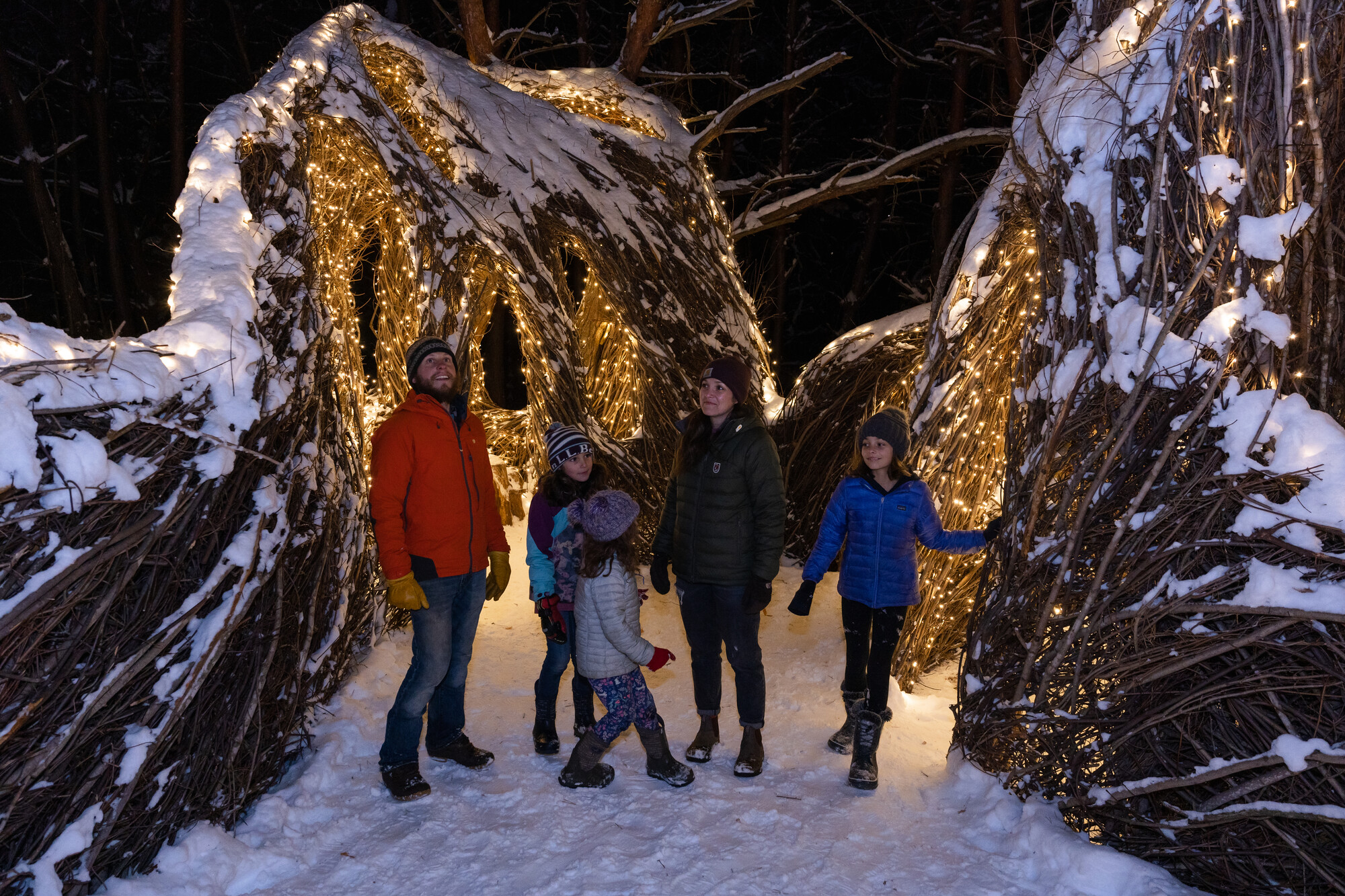 A family walking an interpretive and artistic trail in the winter at the Wild Center