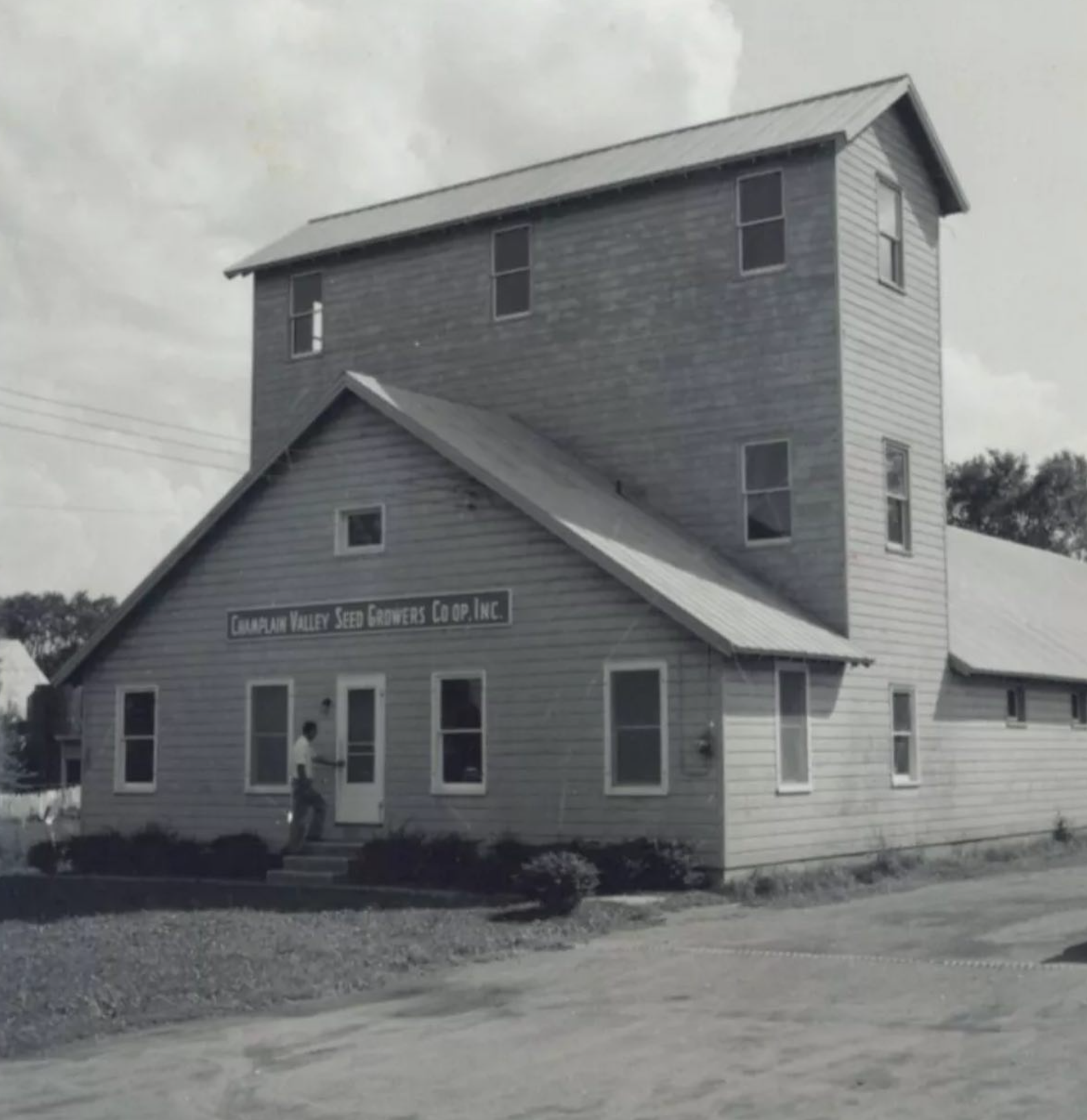 Old, black and white image of a three-story mill in Westport