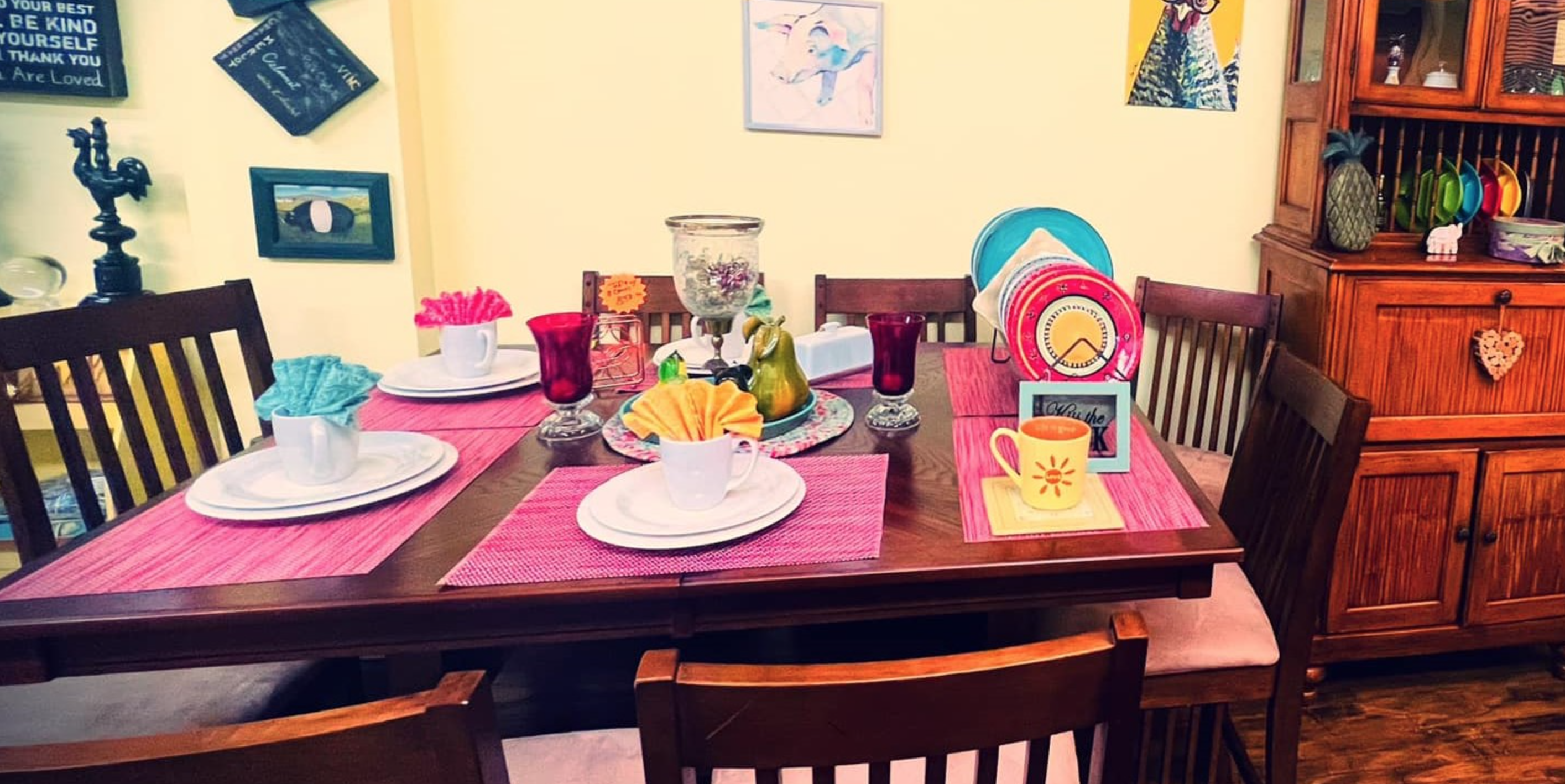 Dinnerware on display on a table, with more items hanging on the wall at a bright second-hand shop.