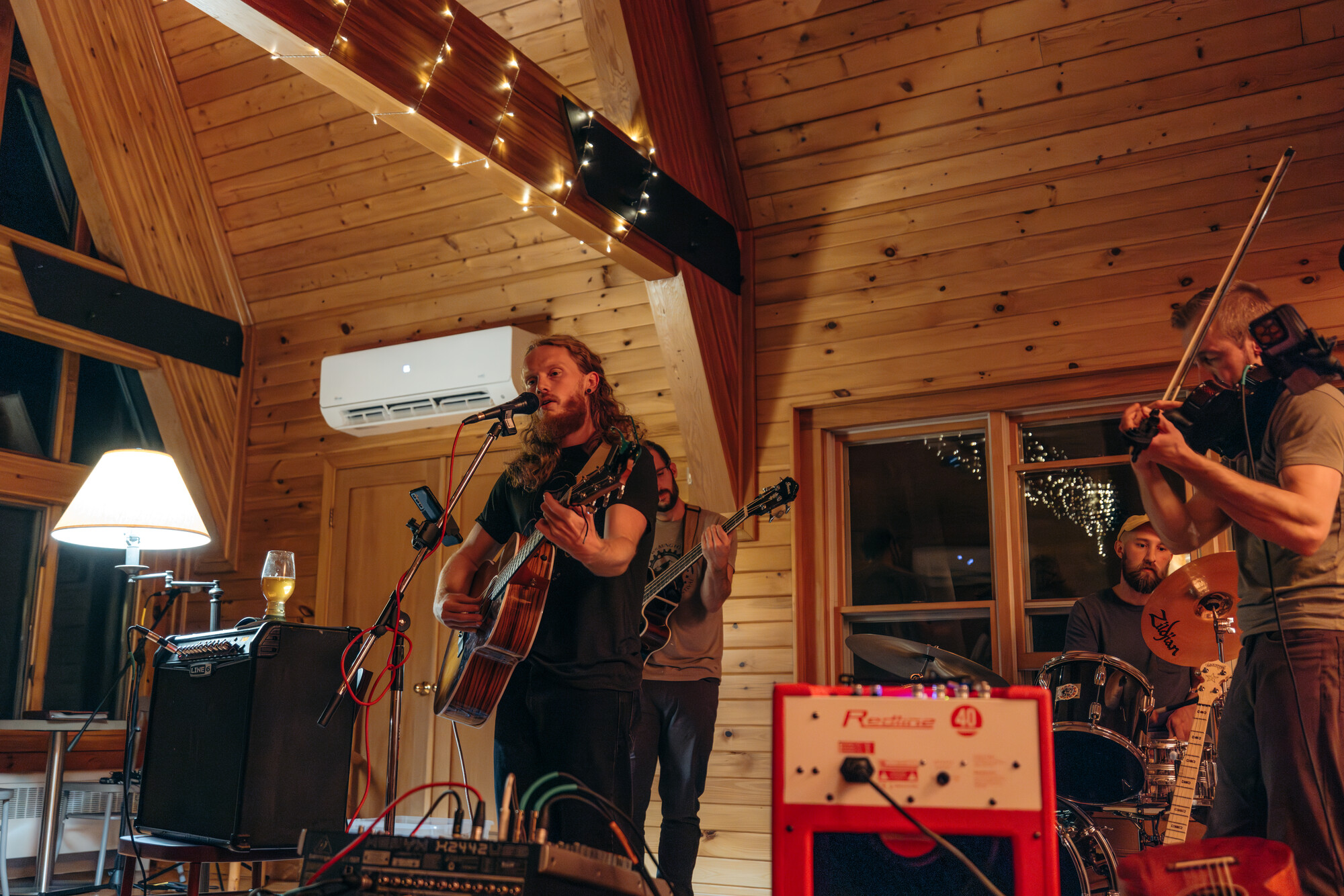 A band plays in a warm lit lodge. 