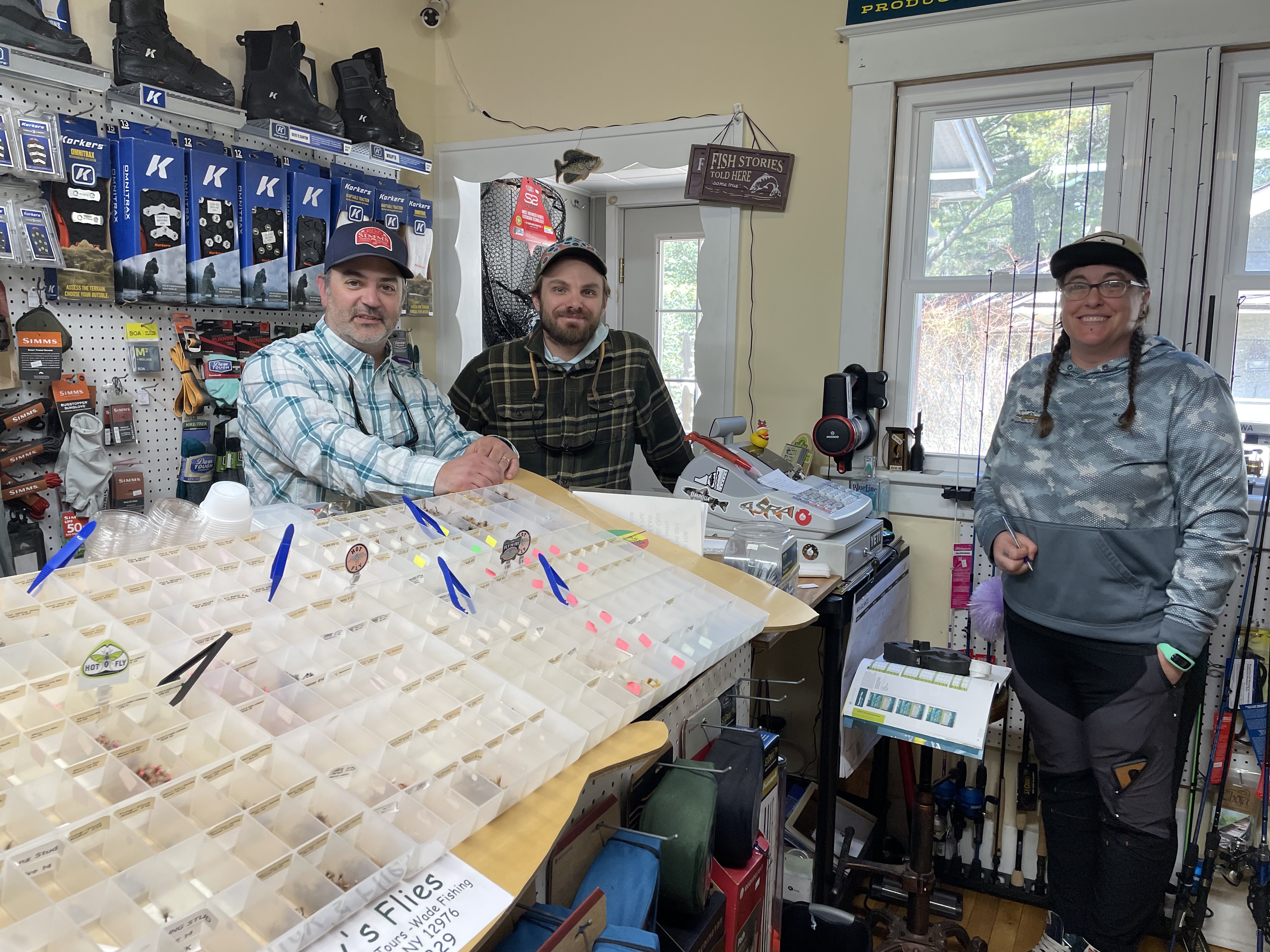 Three fishing guides inside a fly shop.