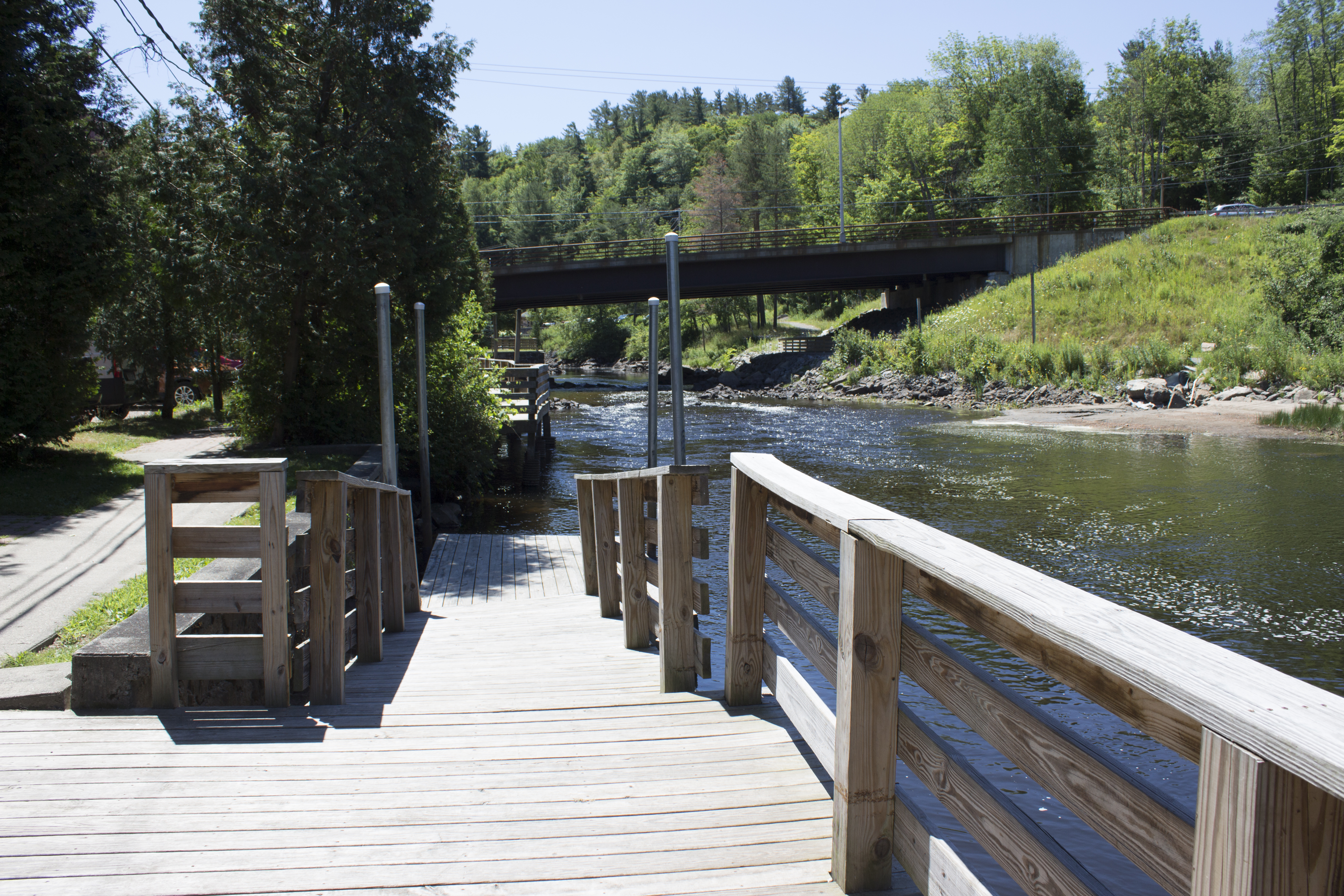 A bridge extends over a river on a sunny day.