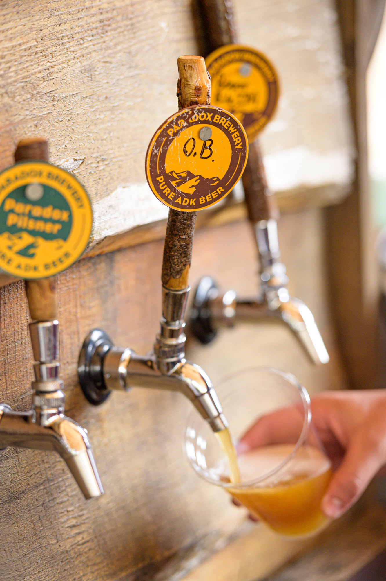 Close-up of a row of beer taps, with one filling a glass.