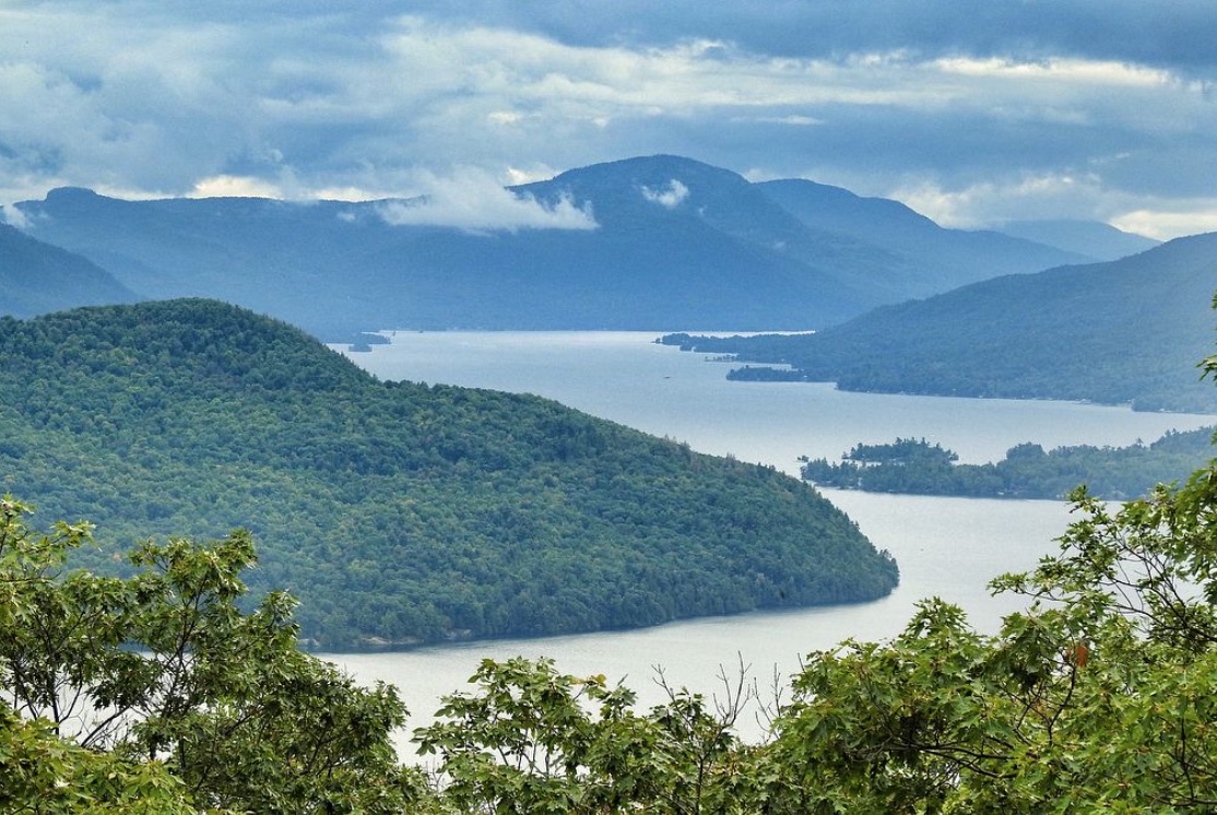 A long view down to a narrow area of Lake Champlain, surrounded by rolling hills.