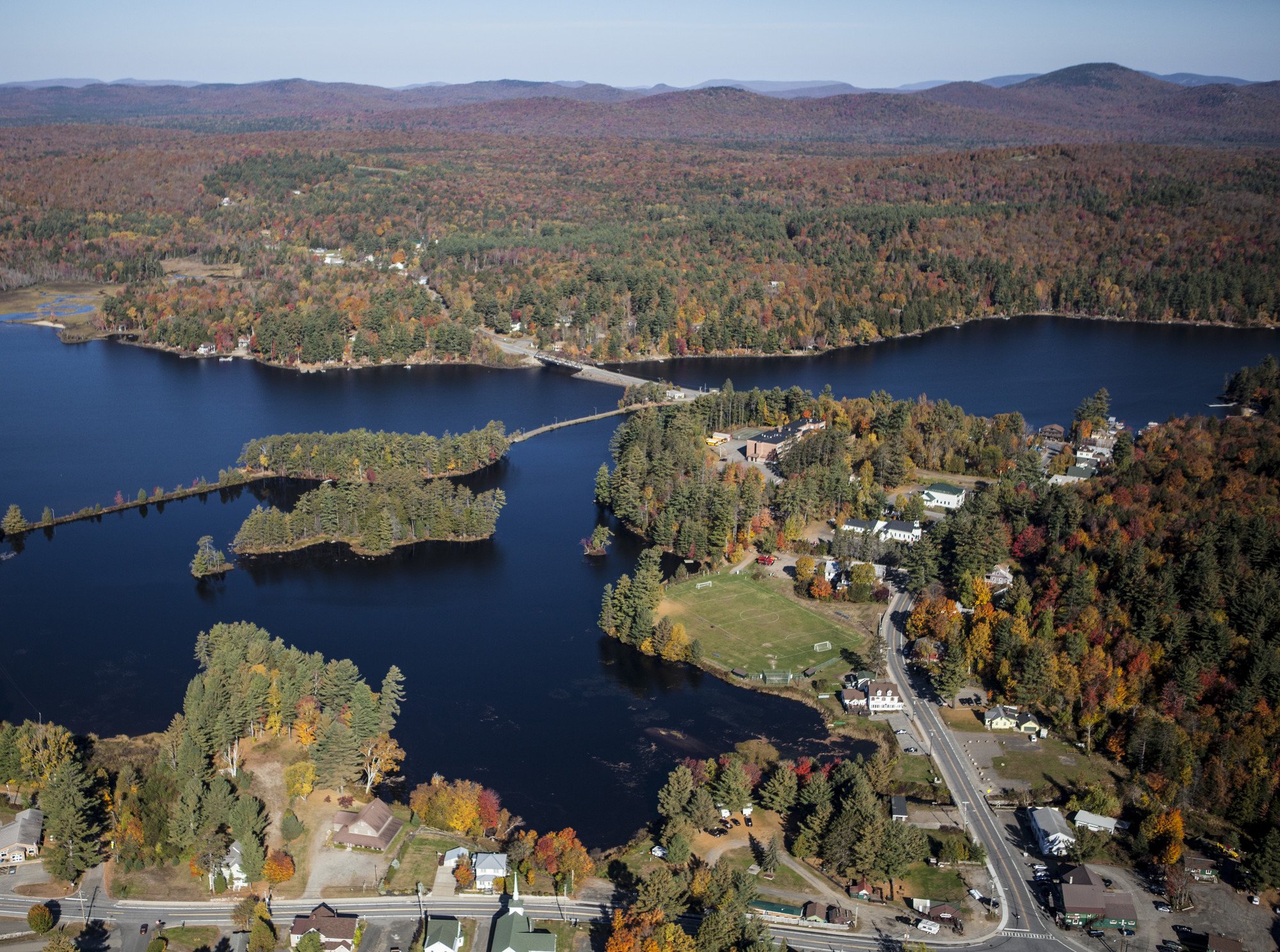 an aerial picture of a small lake town in fall. 