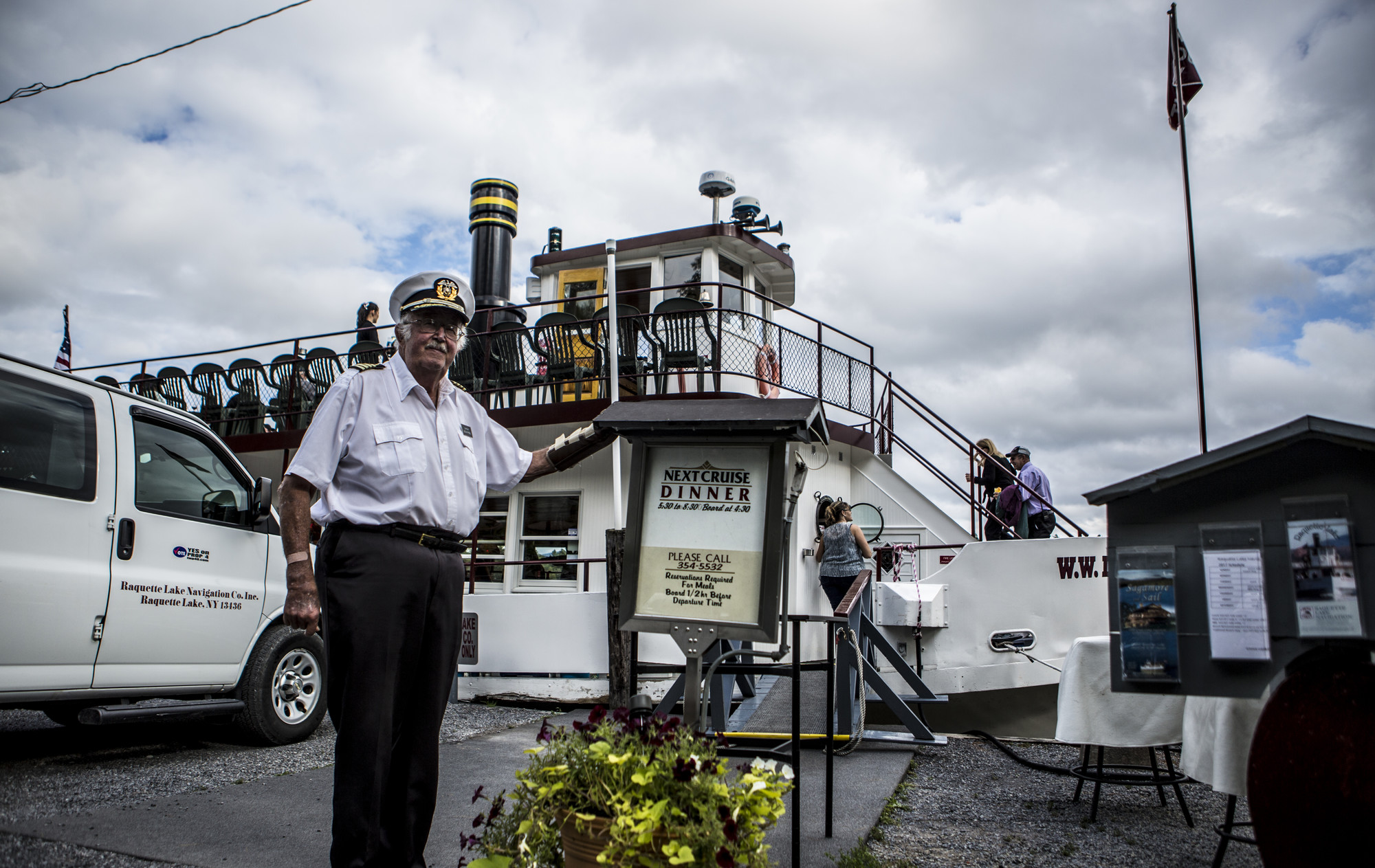 A boat Captain stands in front of his boat