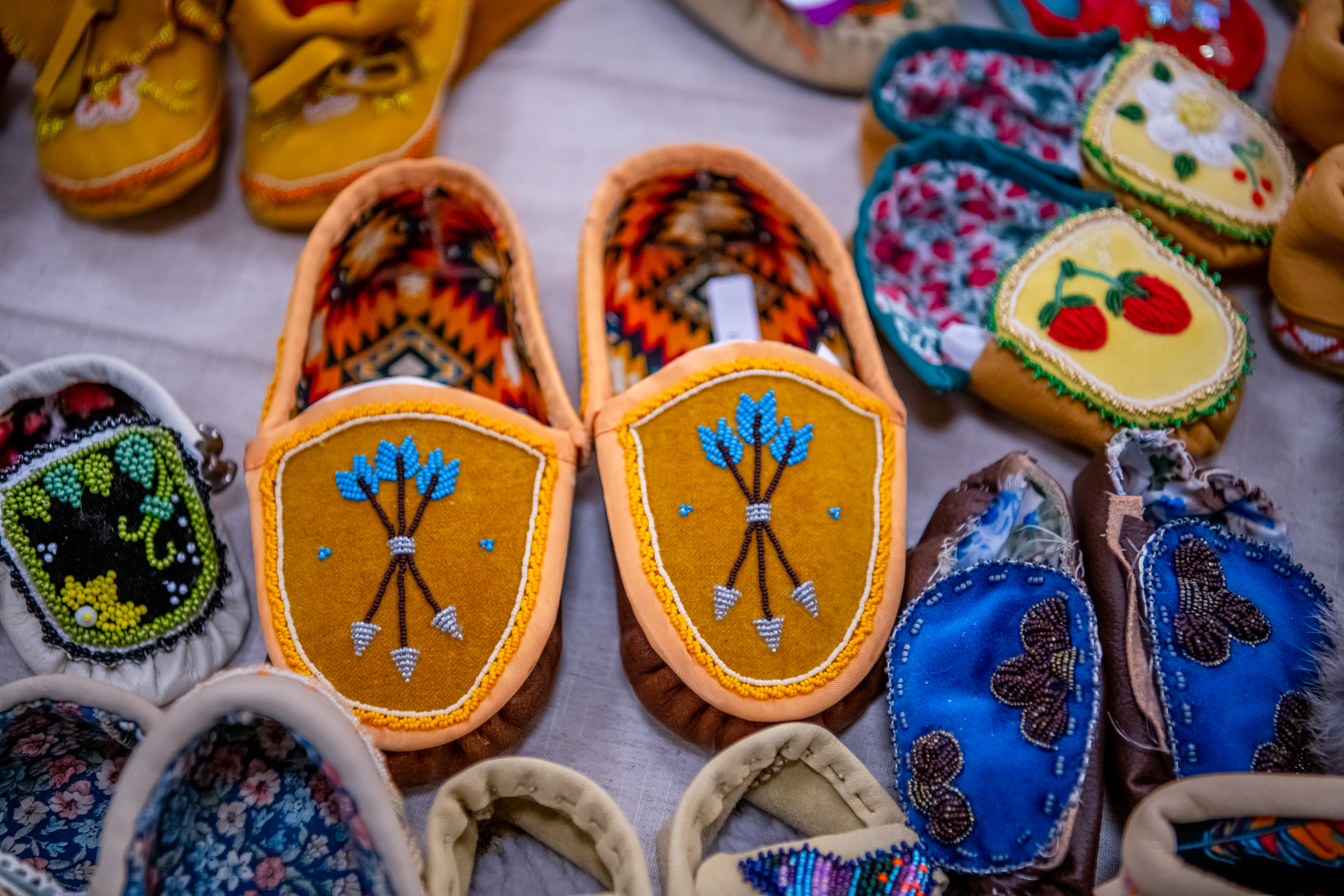 A close-up of handcrafted, beaded moccasins on a table.