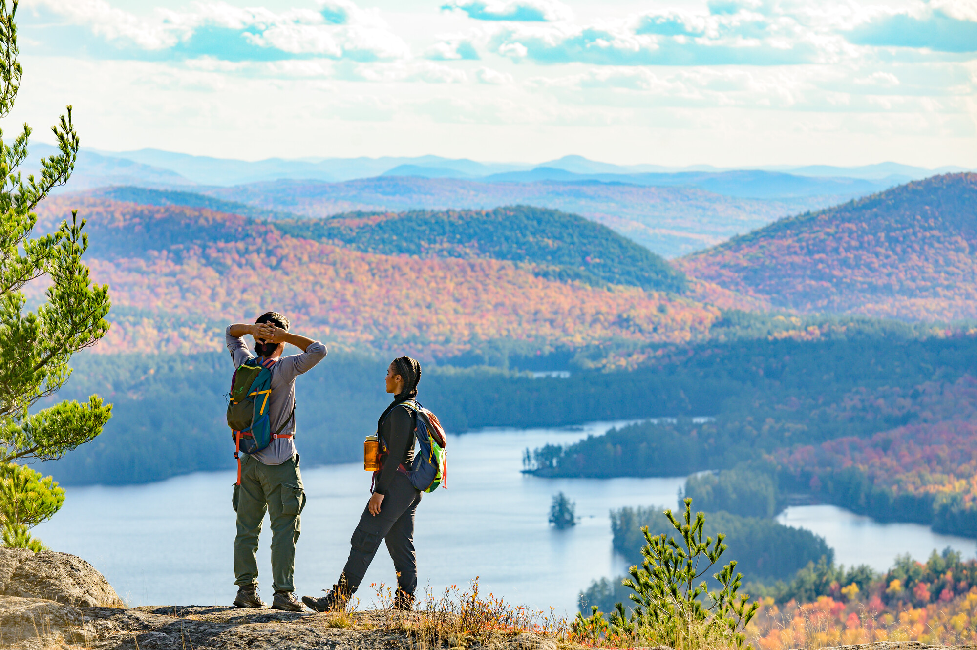 Couple stands at the top of the Treadway Mountain trail with fall scenery.