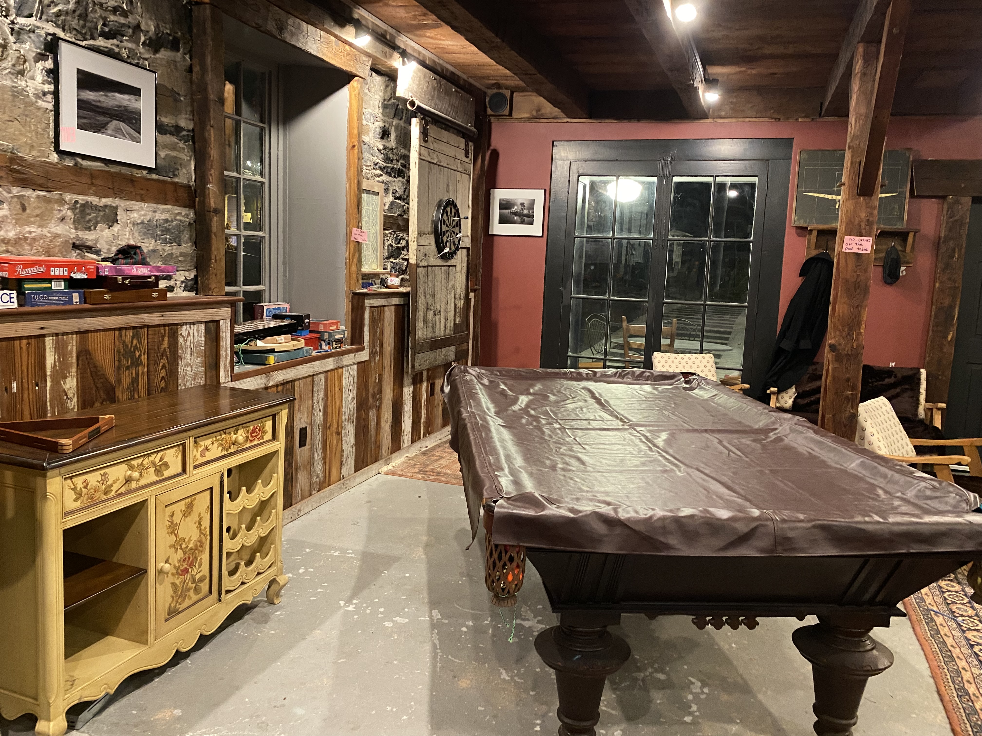 A game corner with a pool table, dart board, and board game classics.