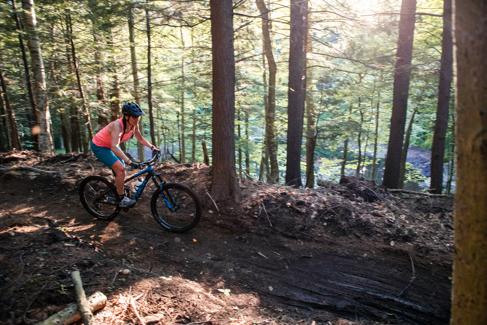 A woman on a mountain bike on a dirt trail.