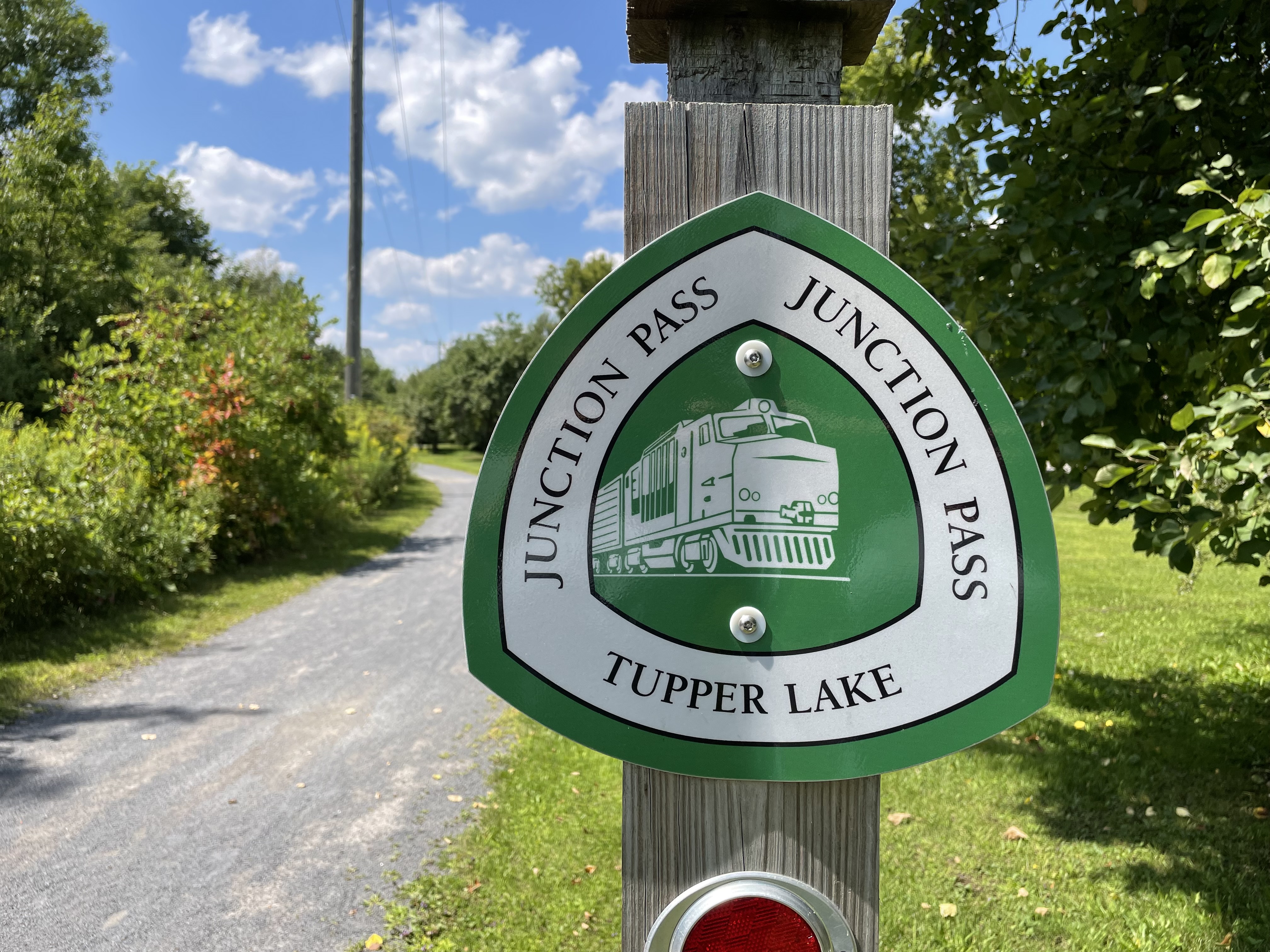 An illustrated trail sign along a path. 