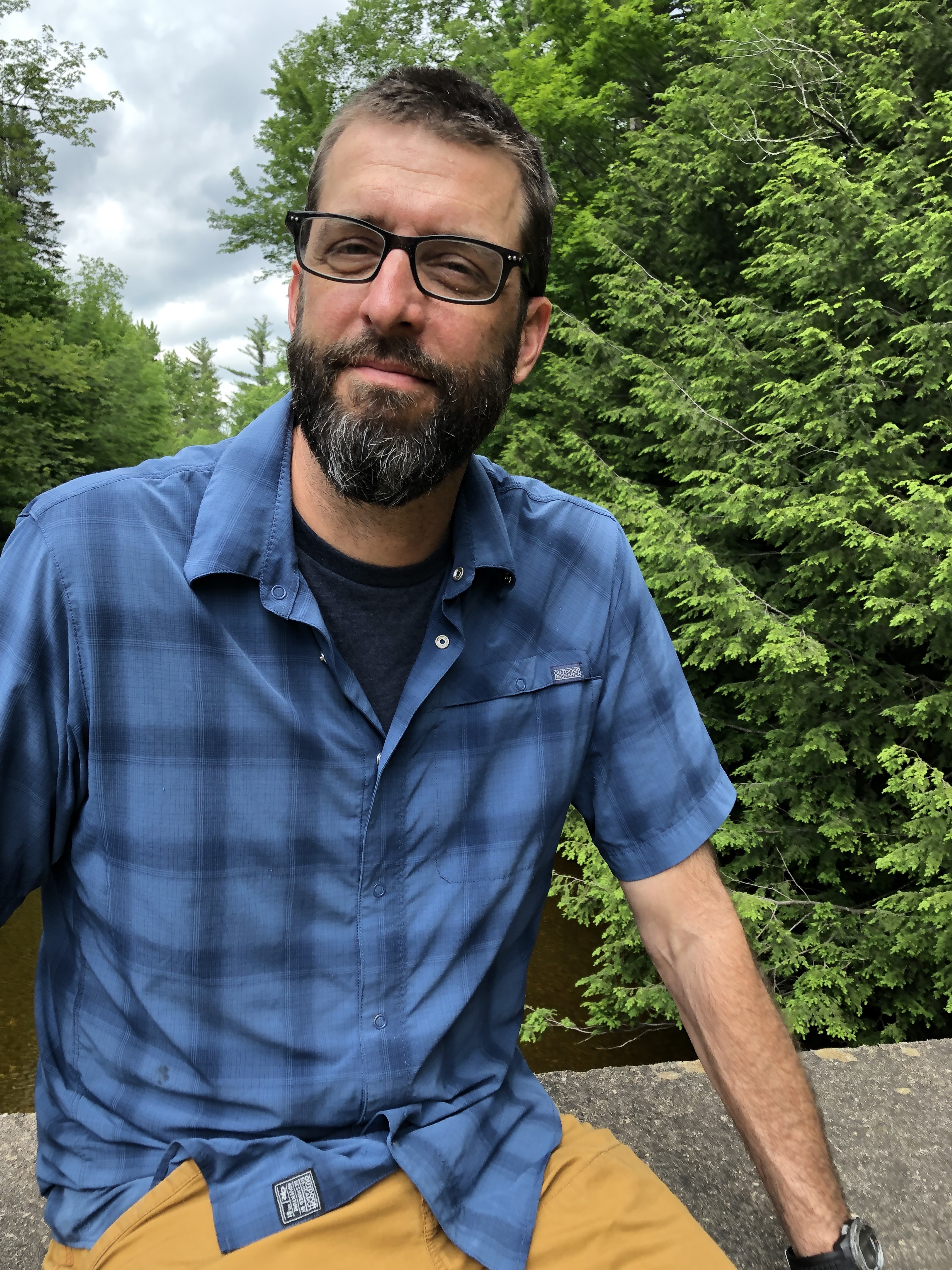Photo of Jason Smith sitting in front of trees