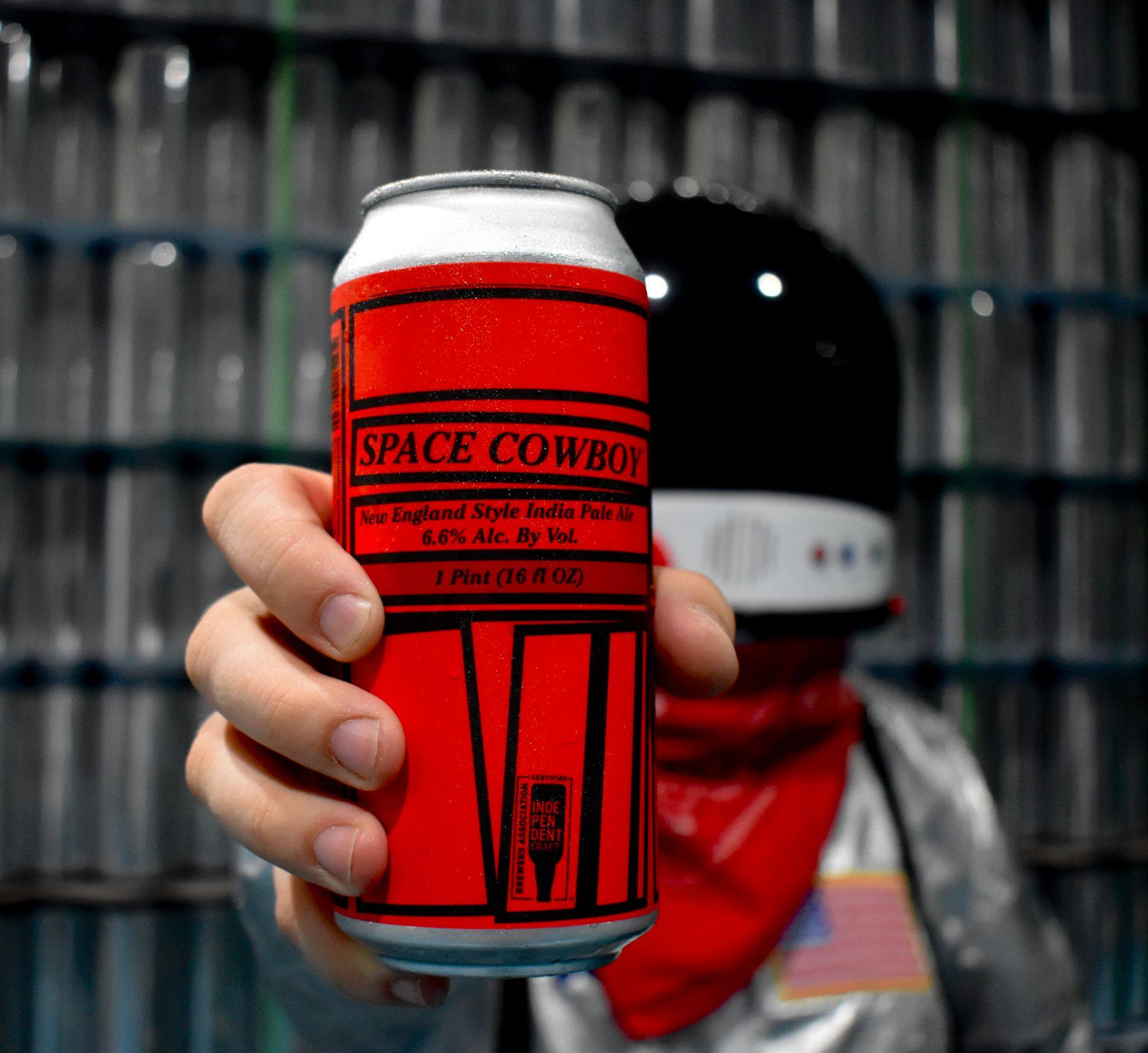 A beer in a can with a red label with black text.