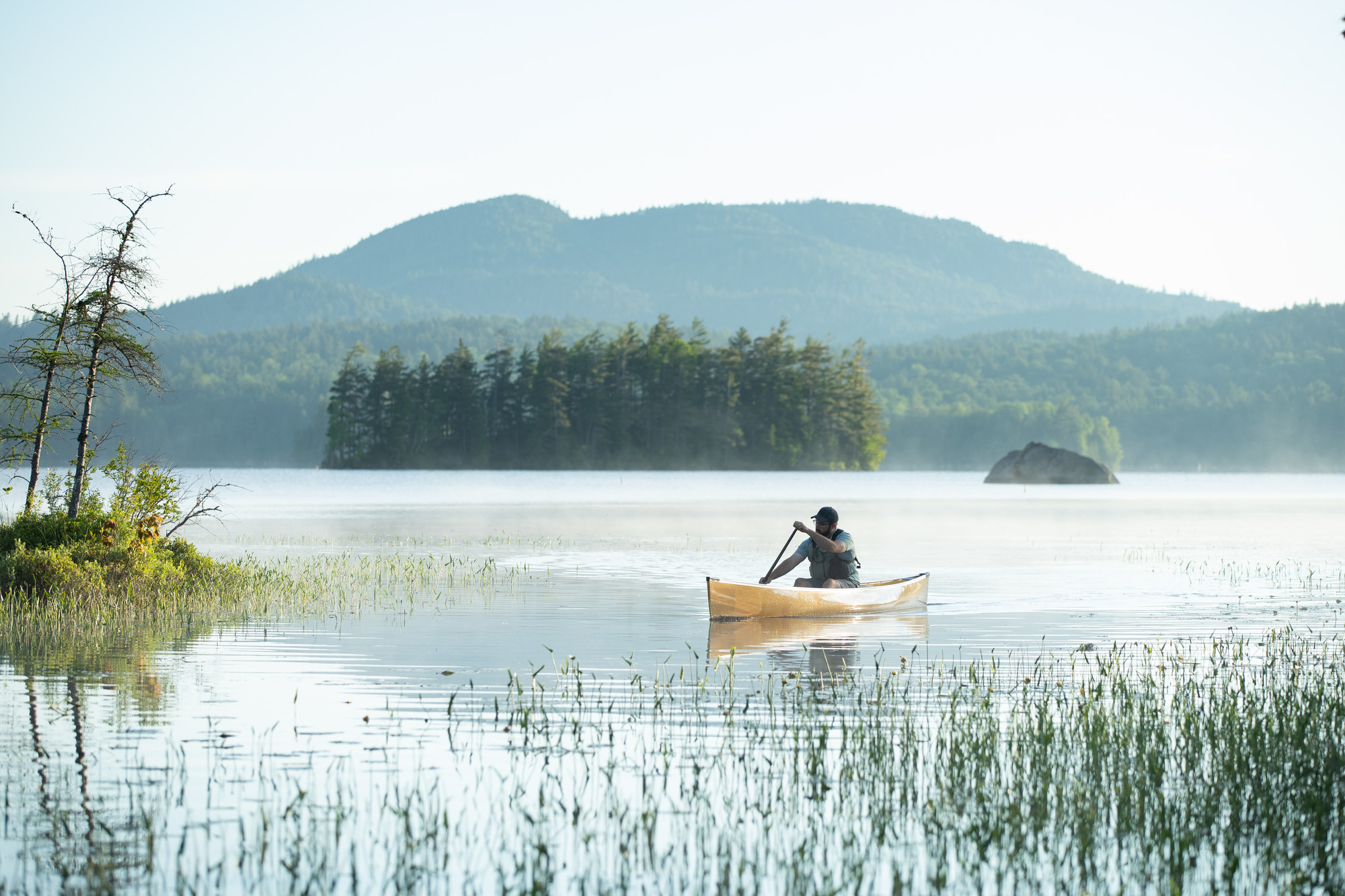 A person canoes on the water.