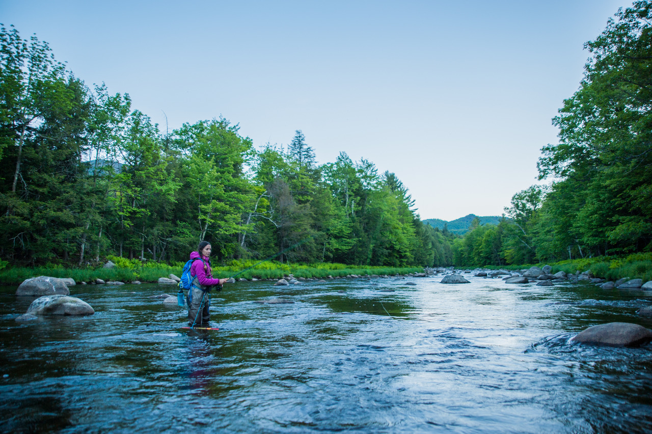 A person wades in the river while fishing