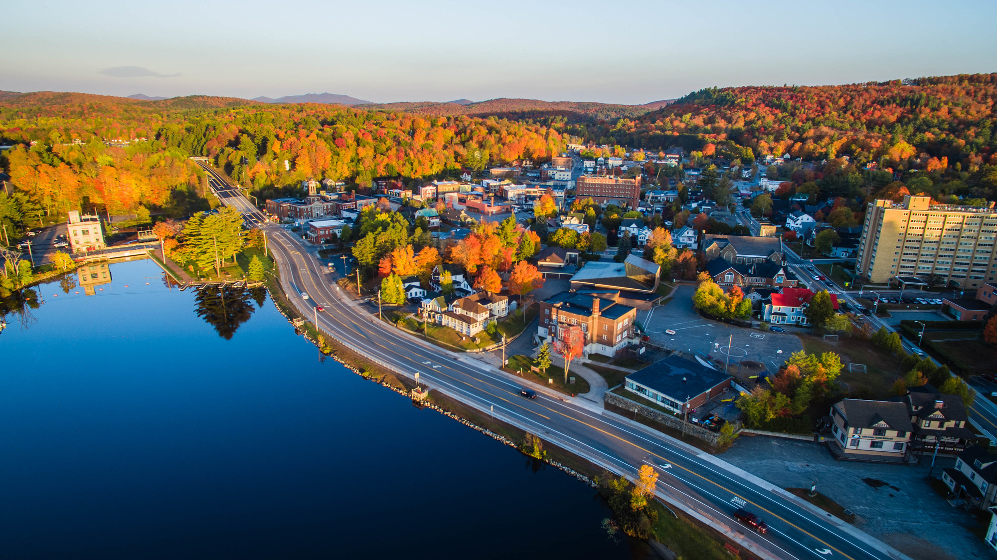 Saranac Lake's fall dining options are as delicious as it beautiful here An aerial shot of downtown Saranac Lake. Fall foliage, lakes, buildings, and the highway are featured.