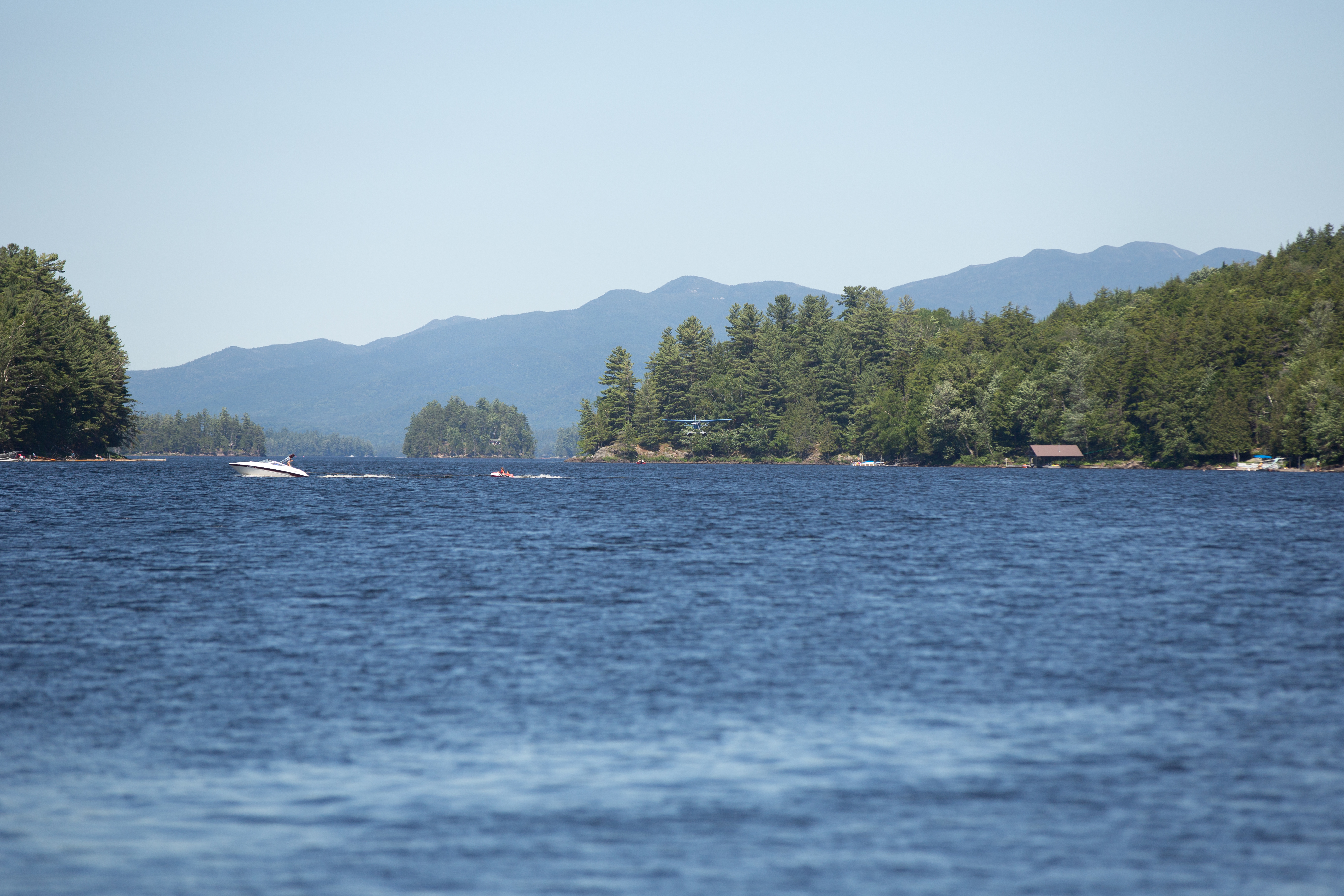 Boating across Long Lake, with a floatplane about to land on the water.
