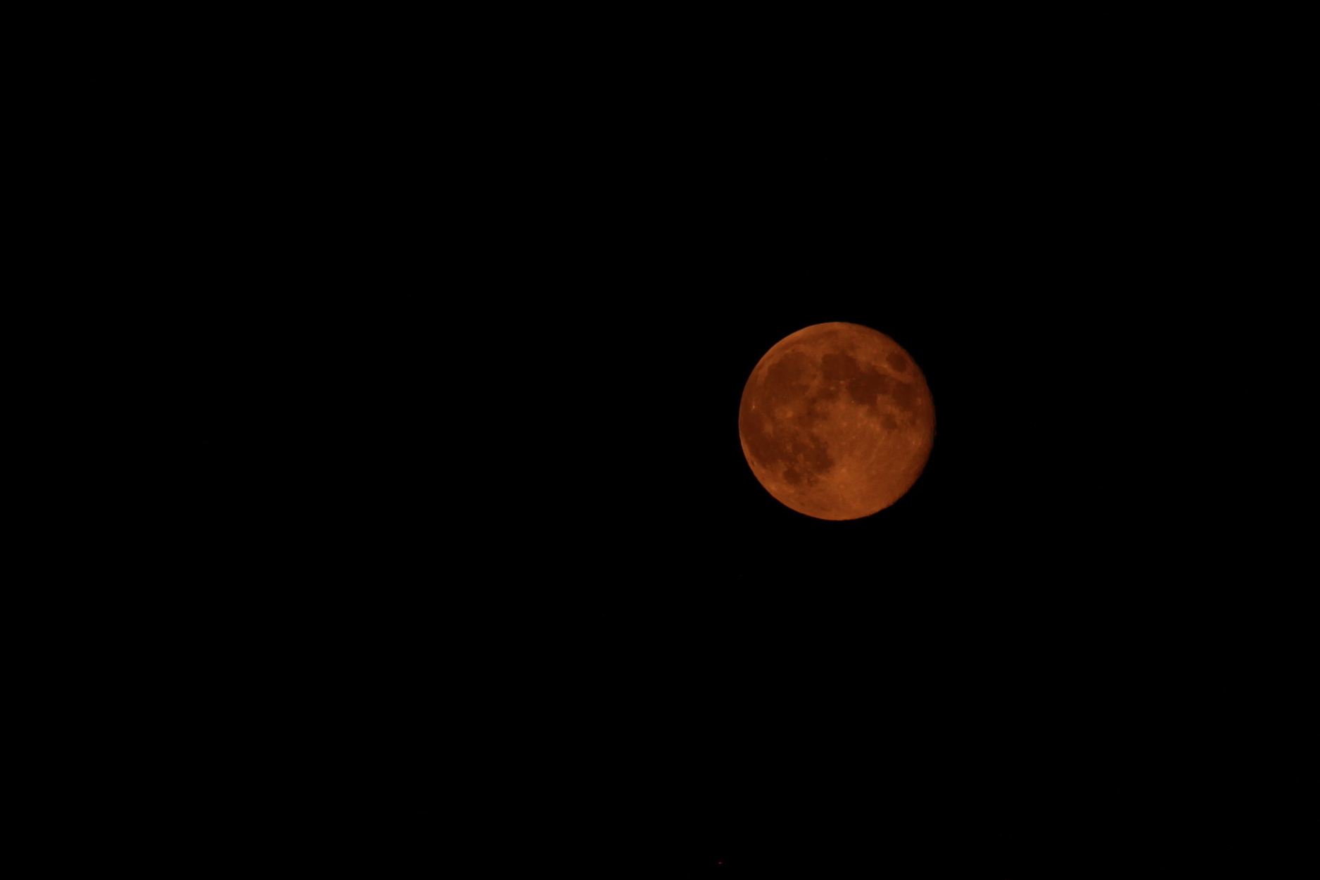 The moon appears reddish orange during a lunar eclipse.
