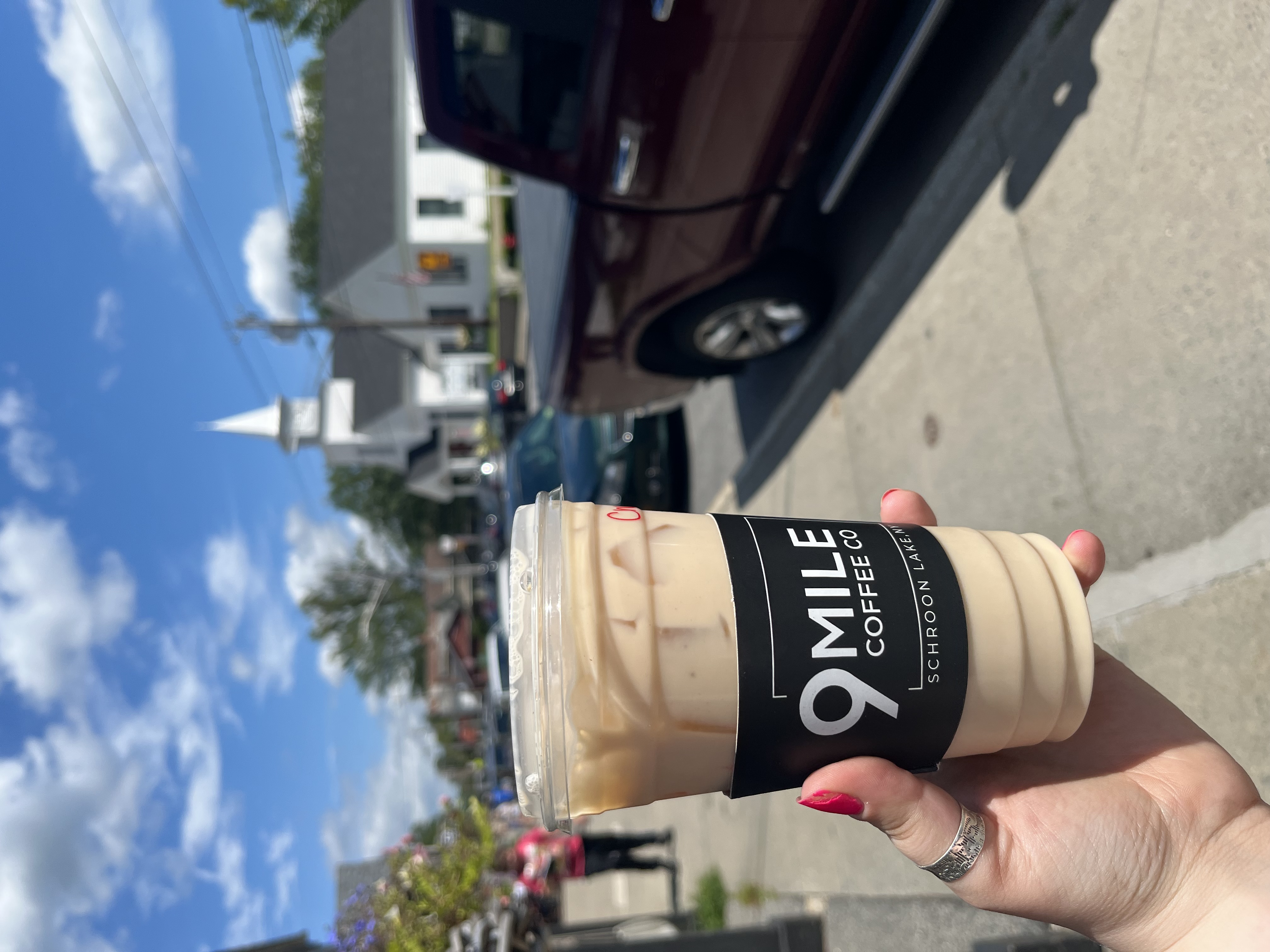 Holding up a cup of coffee from 9 mile coffee