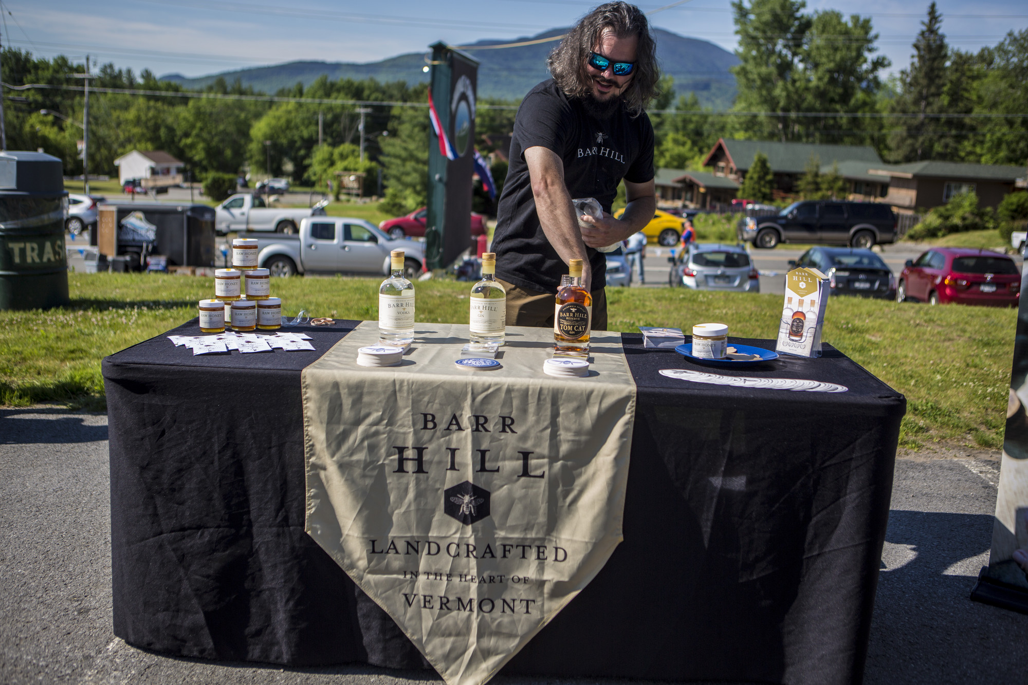 A man tends a whiskey stand serving samples of liquor. 