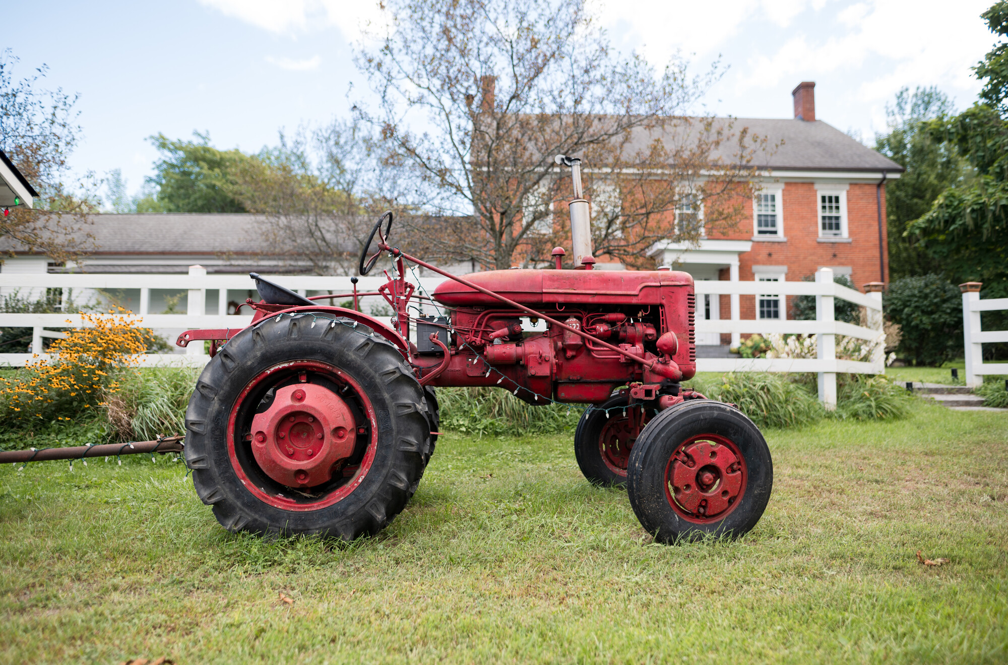 Lake Champlain Region lodging with a red tractor outside in the fall.