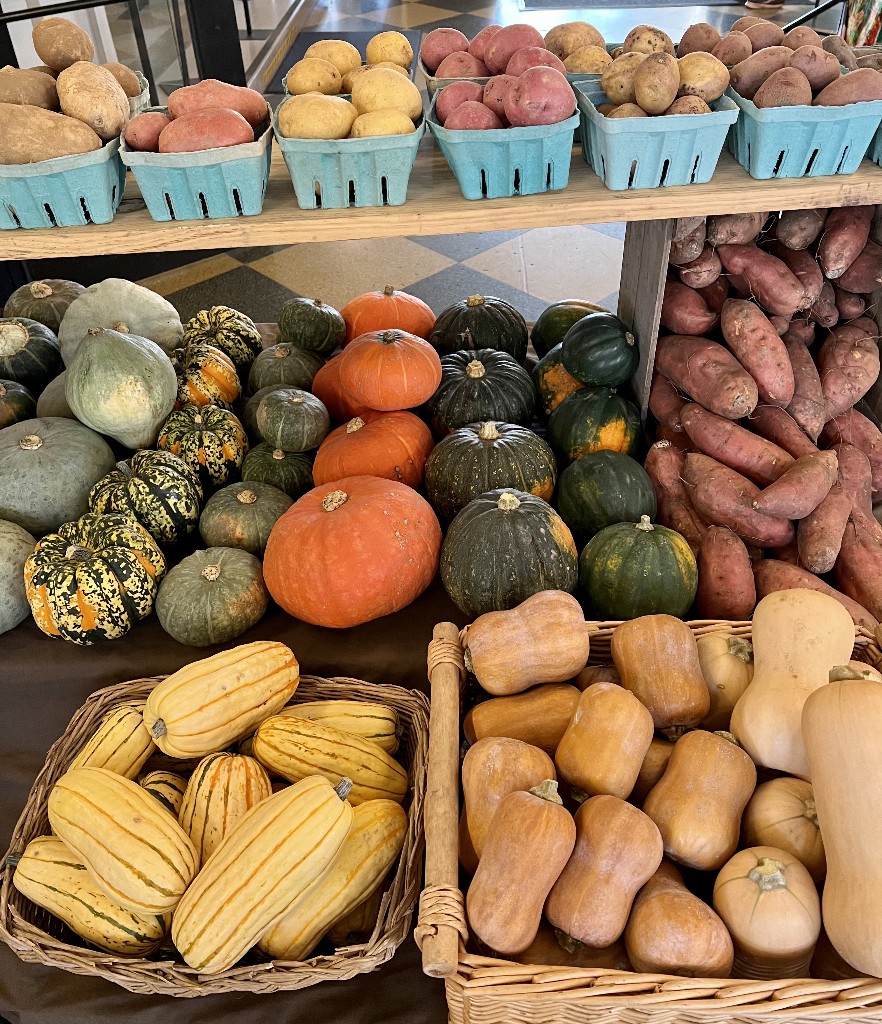 Squash, potatoes, and other winter vegetables displayed on a table