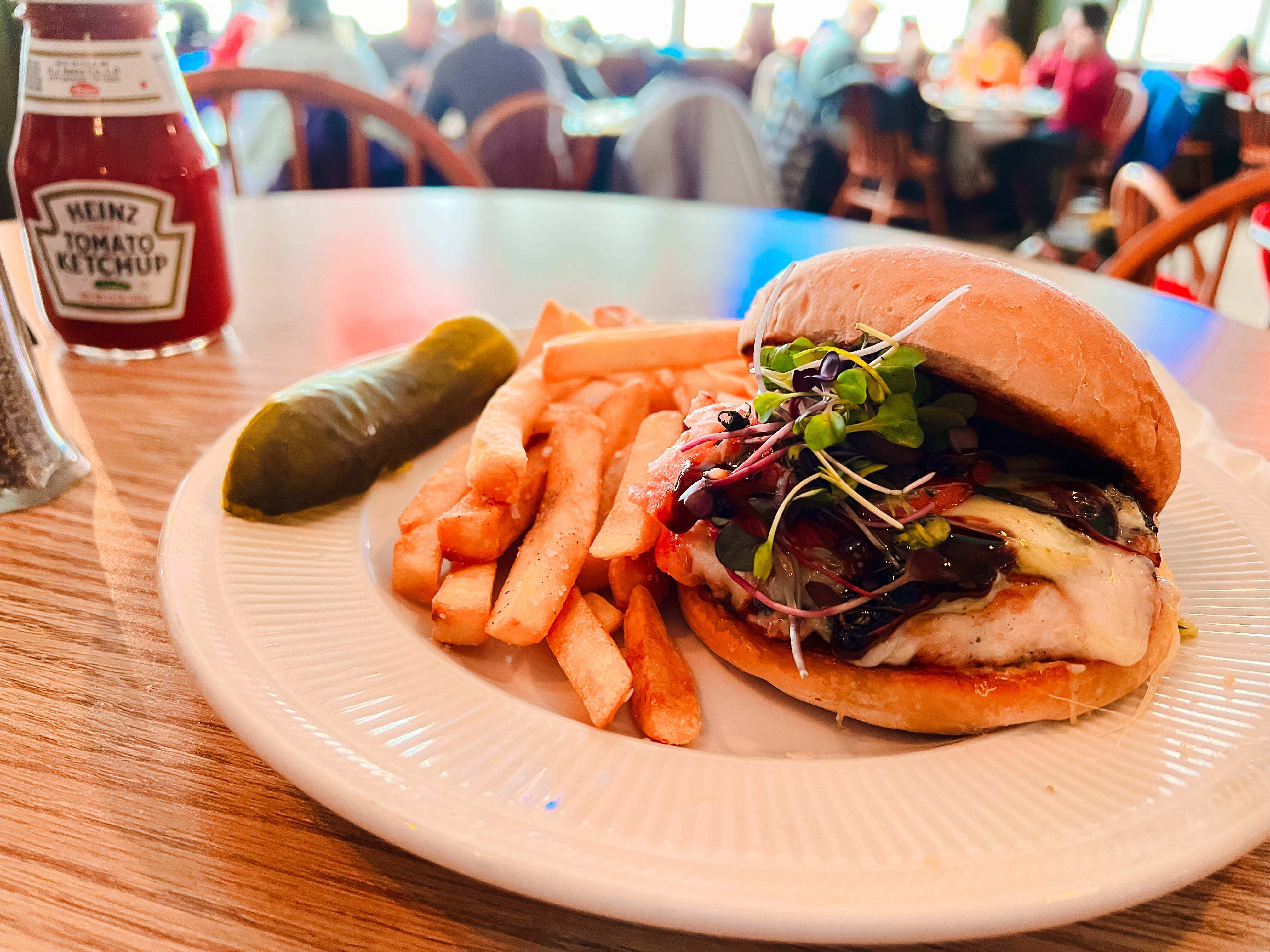 A sandwich that looks mouthwateringly good with french fries and a pickle.