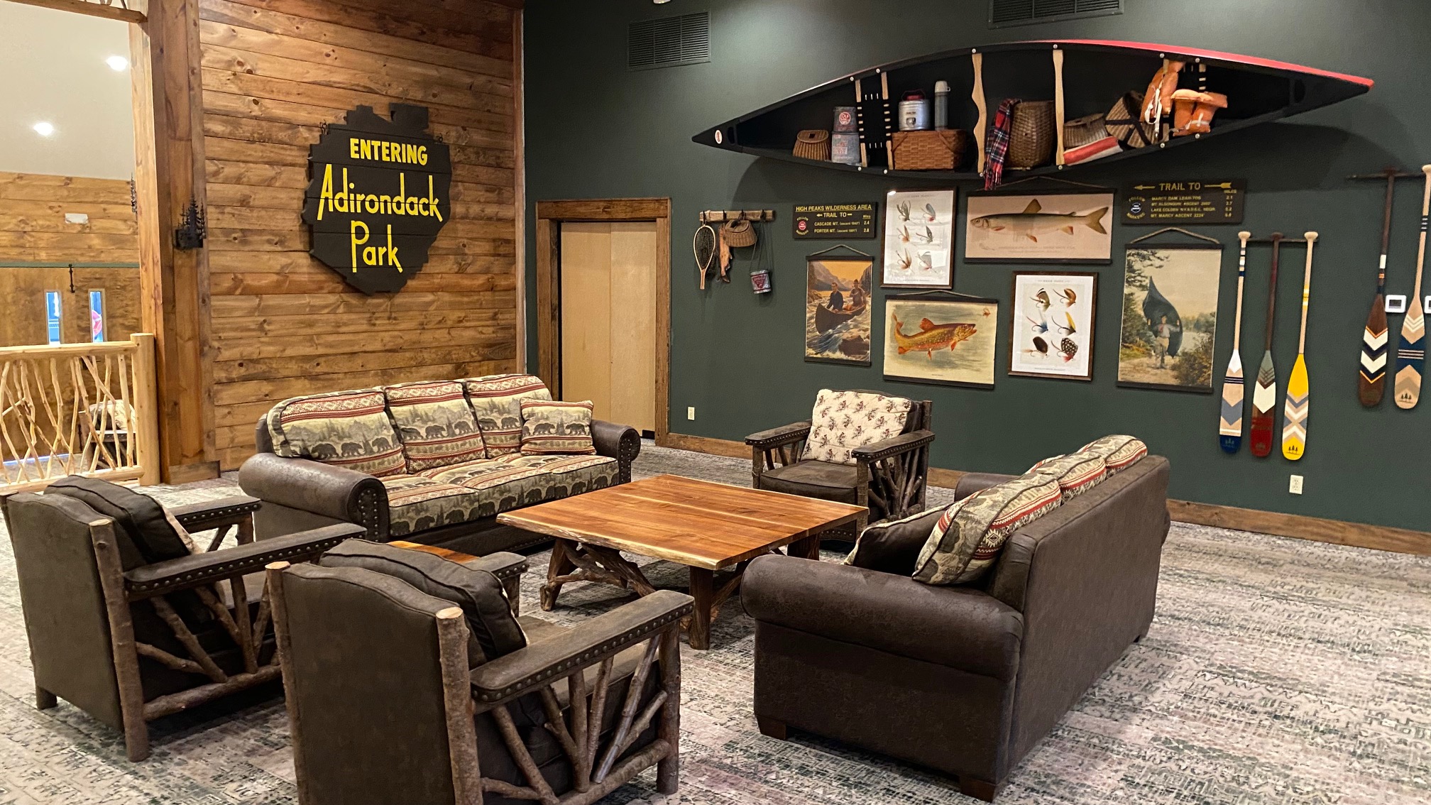 An indoor seating area at The Lodge at Schroon Lake, with sofas, a table, and wall decorations