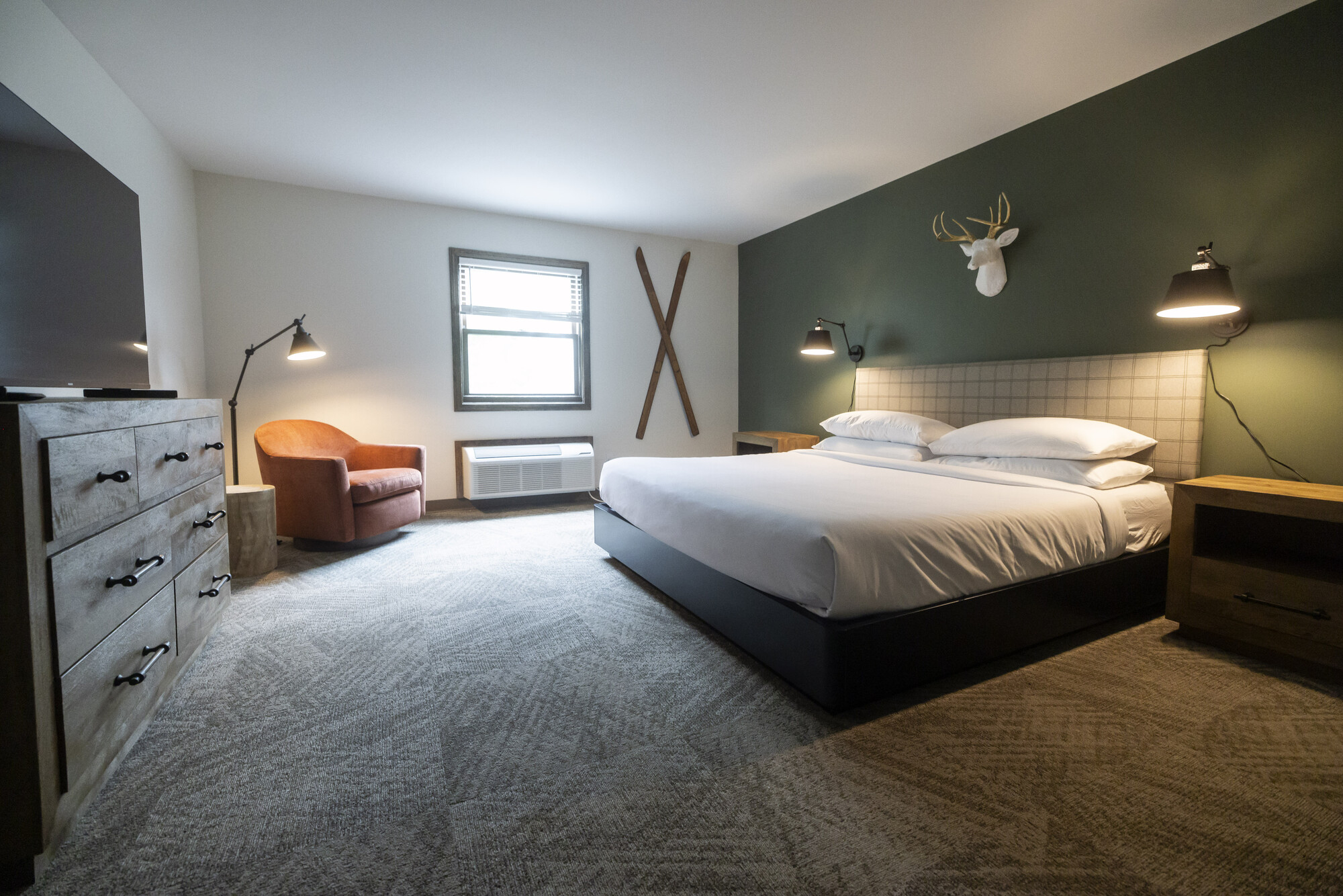 A hotel room with Adirondack inspired decor, including wooden skis on the wall.