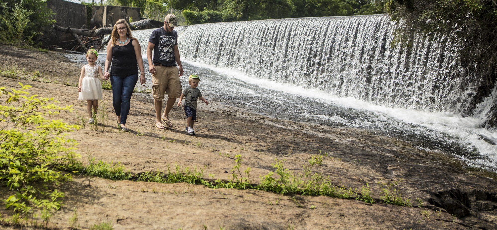 A family walking alongside a waterfall