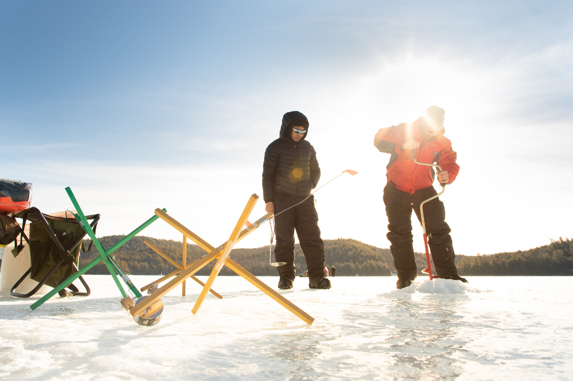 People ice fishing in the bright sun